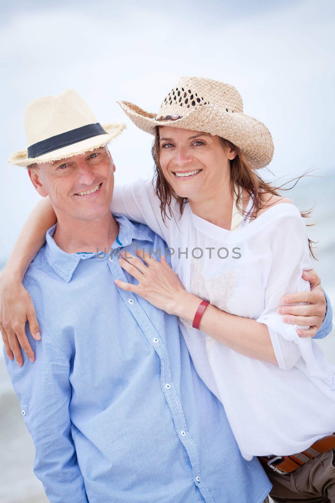 happy adult couple in summertime on beach having fun vacation