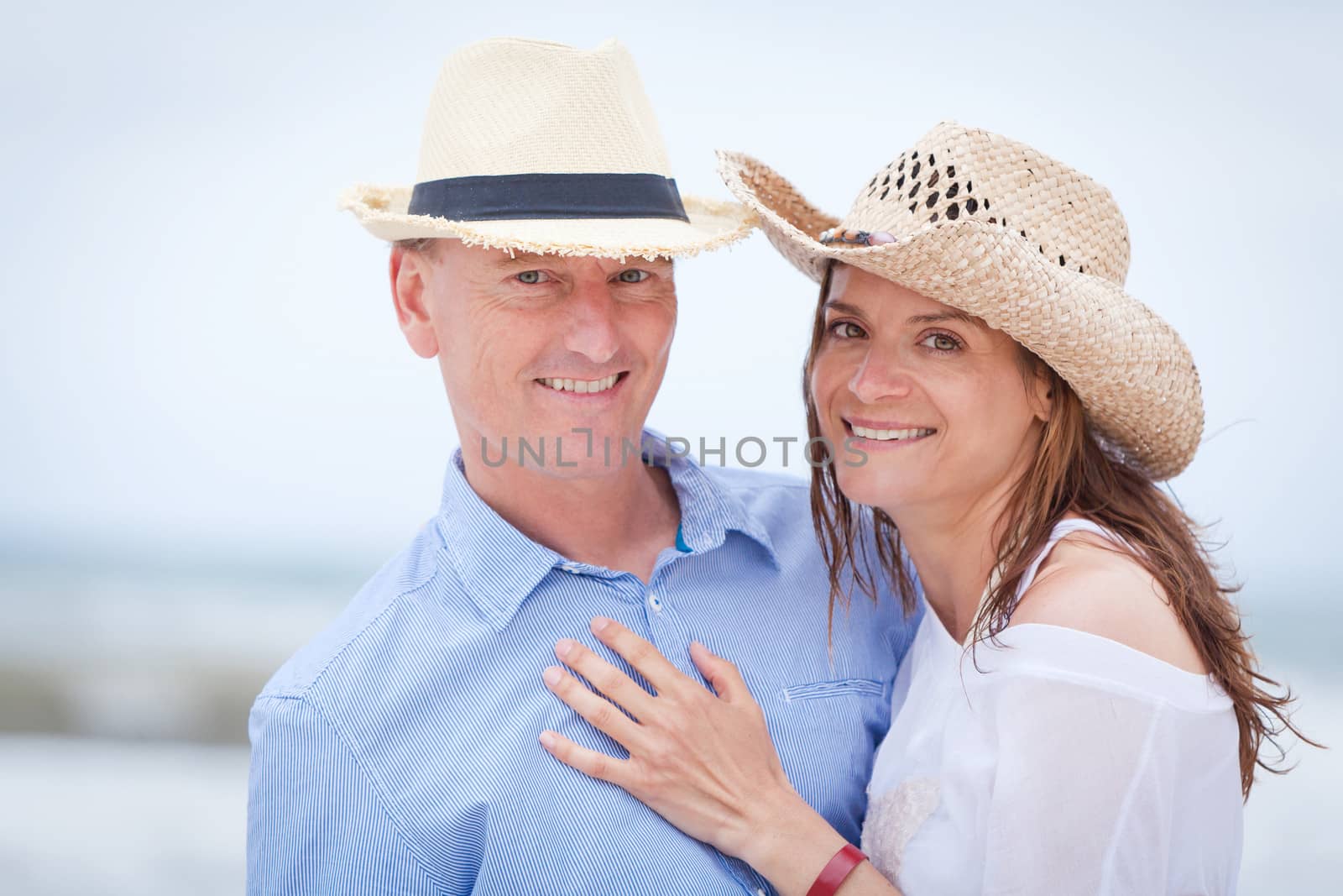 happy adult couple in summertime on beach having fun vacation