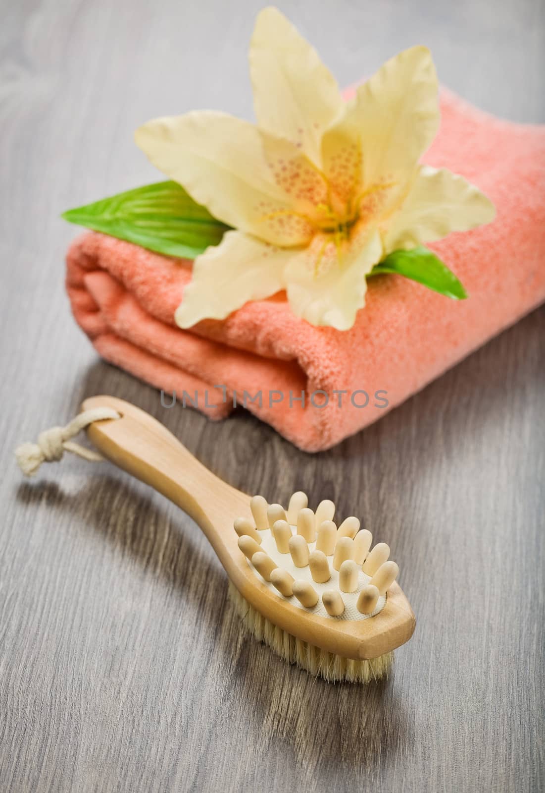 flower on pink towel with massager and brush