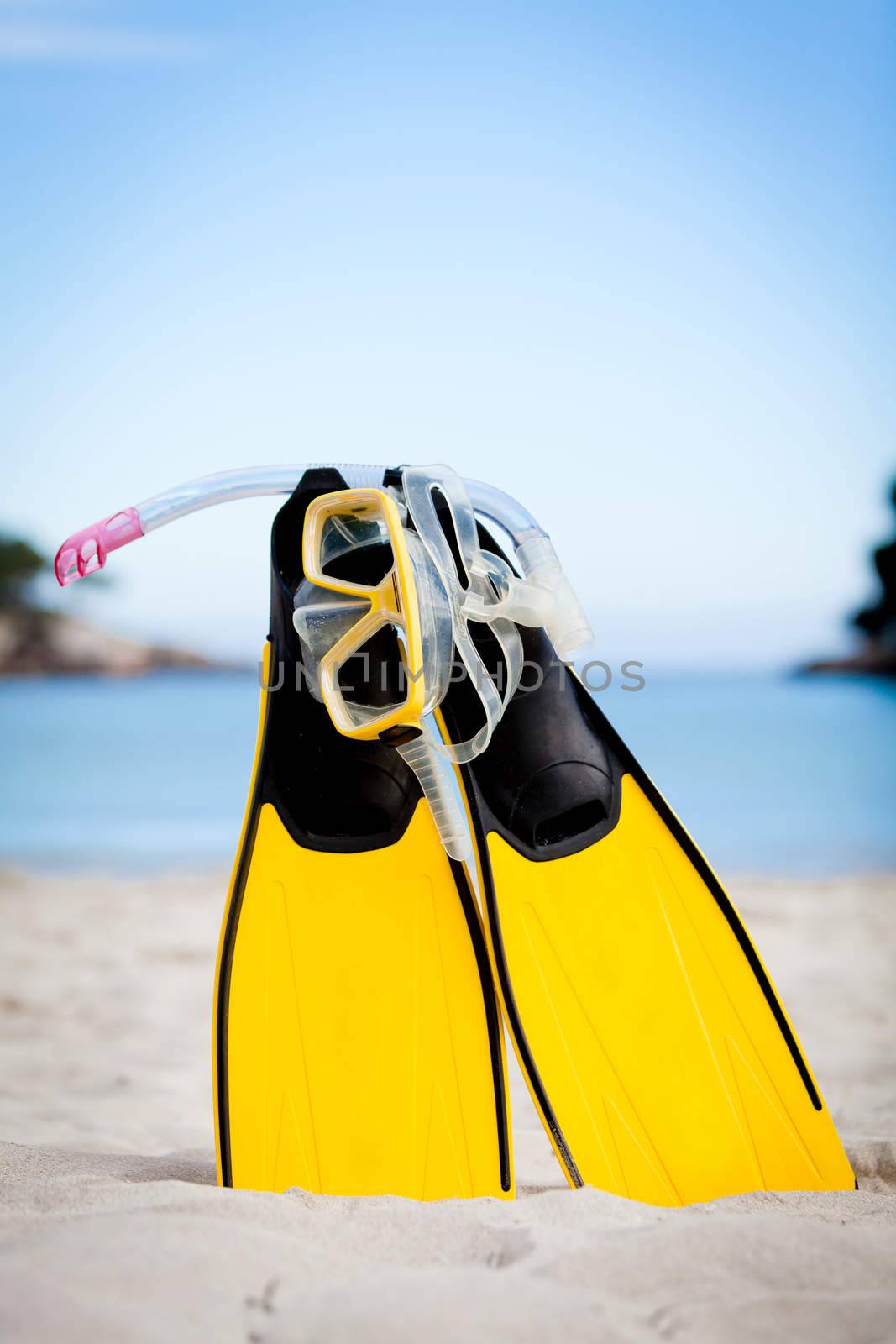 yellow fins and snorkelling mask on beach in summer holiday