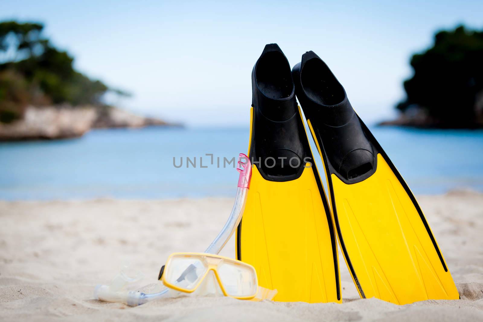 yellow fins and snorkelling mask on beach in summer holiday