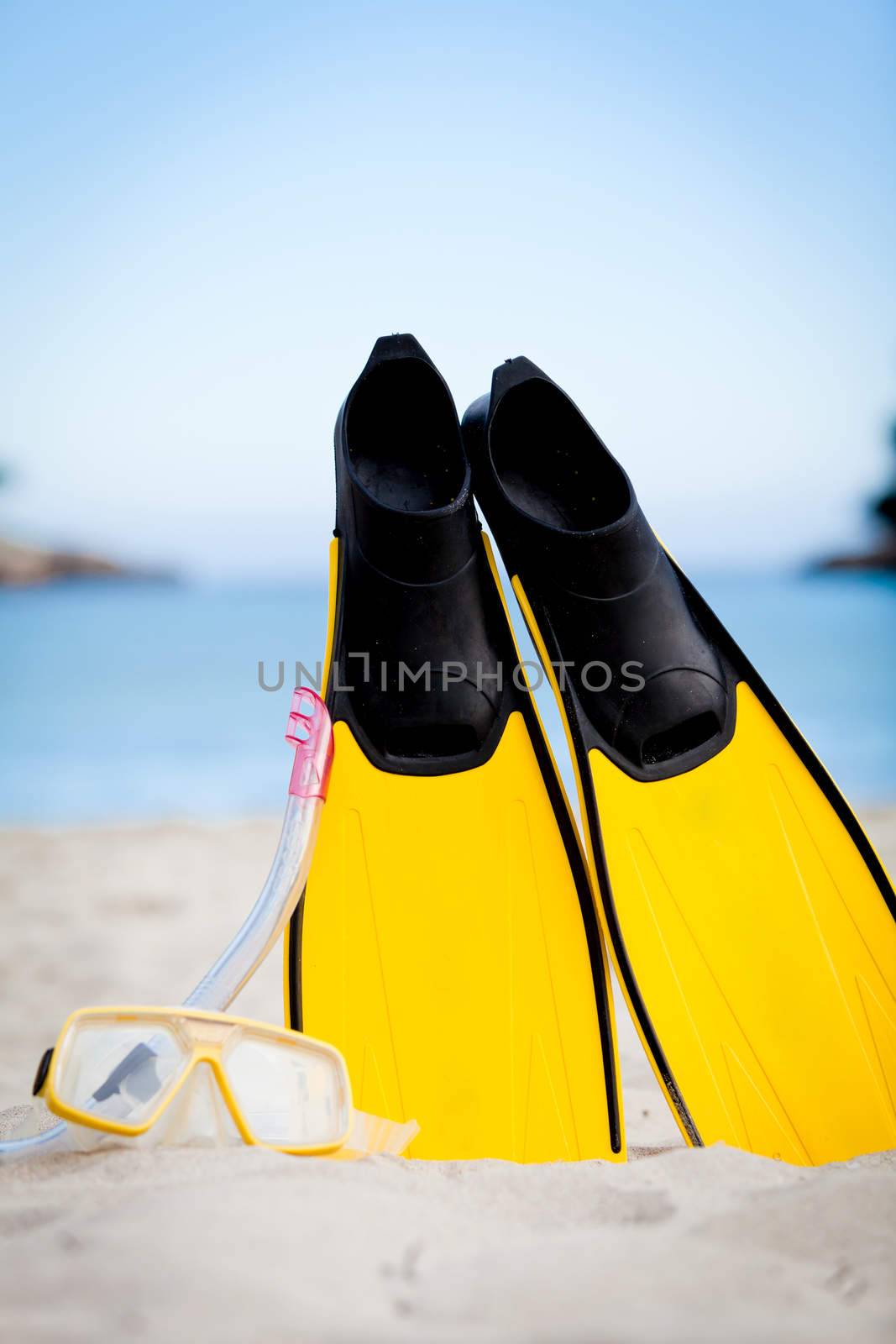 yellow fins and snorkelling mask on beach in summer holiday