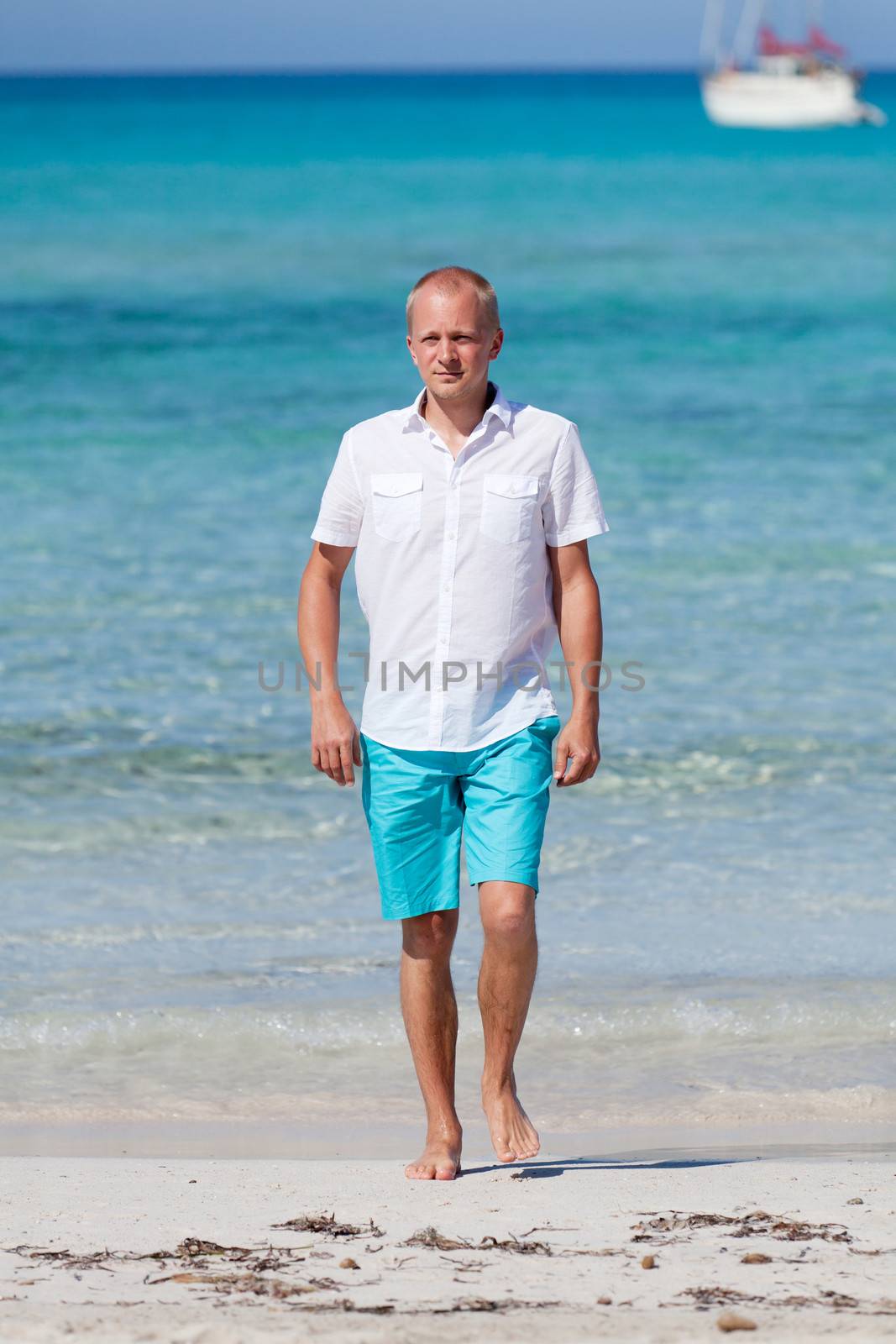 young man walking on the beach in summer holiday vacation