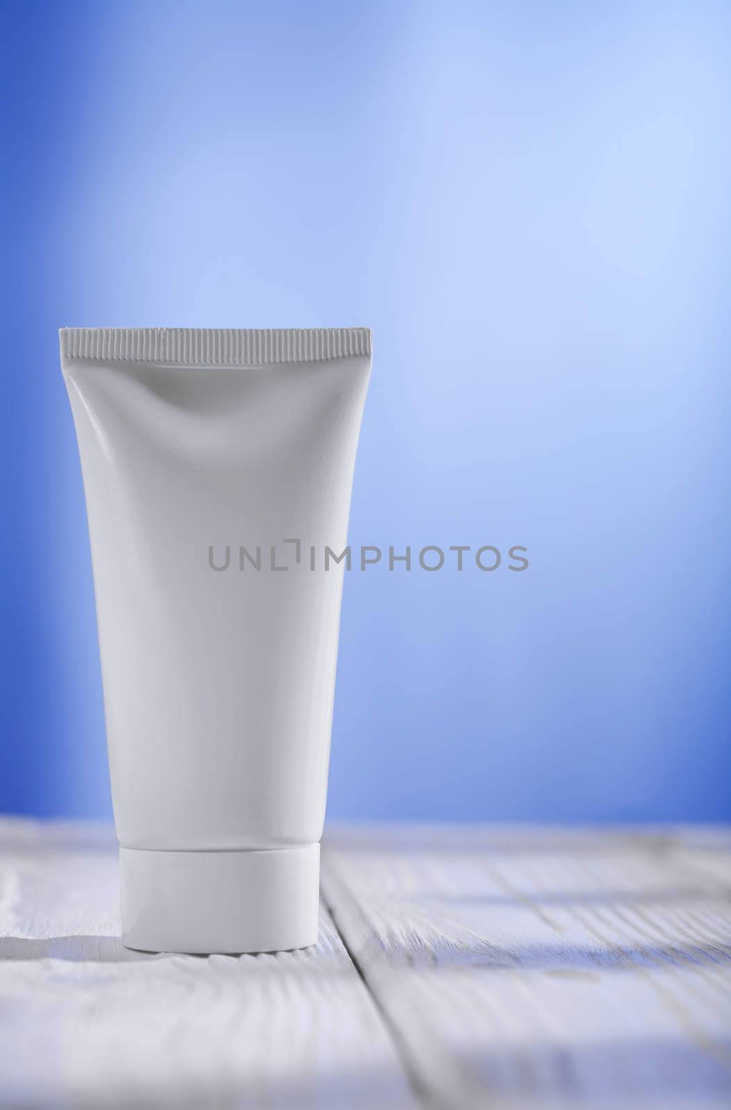 white tube on the table and blue background