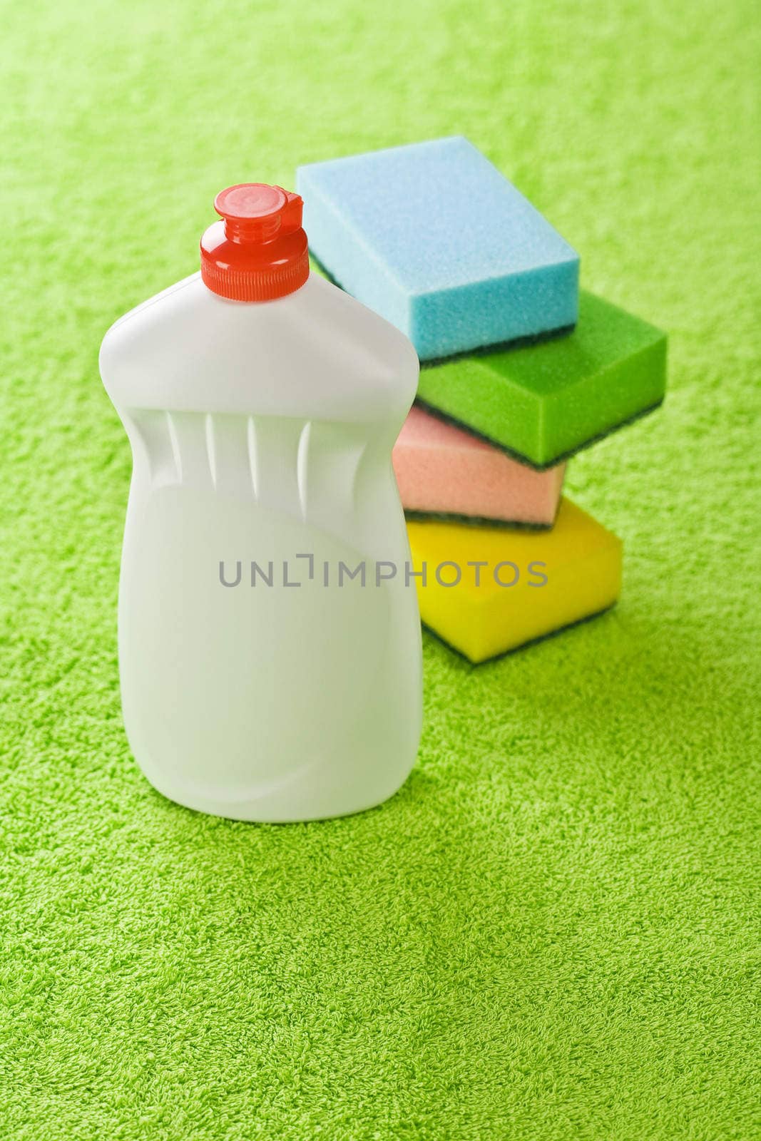 bottle and sponges on green towel