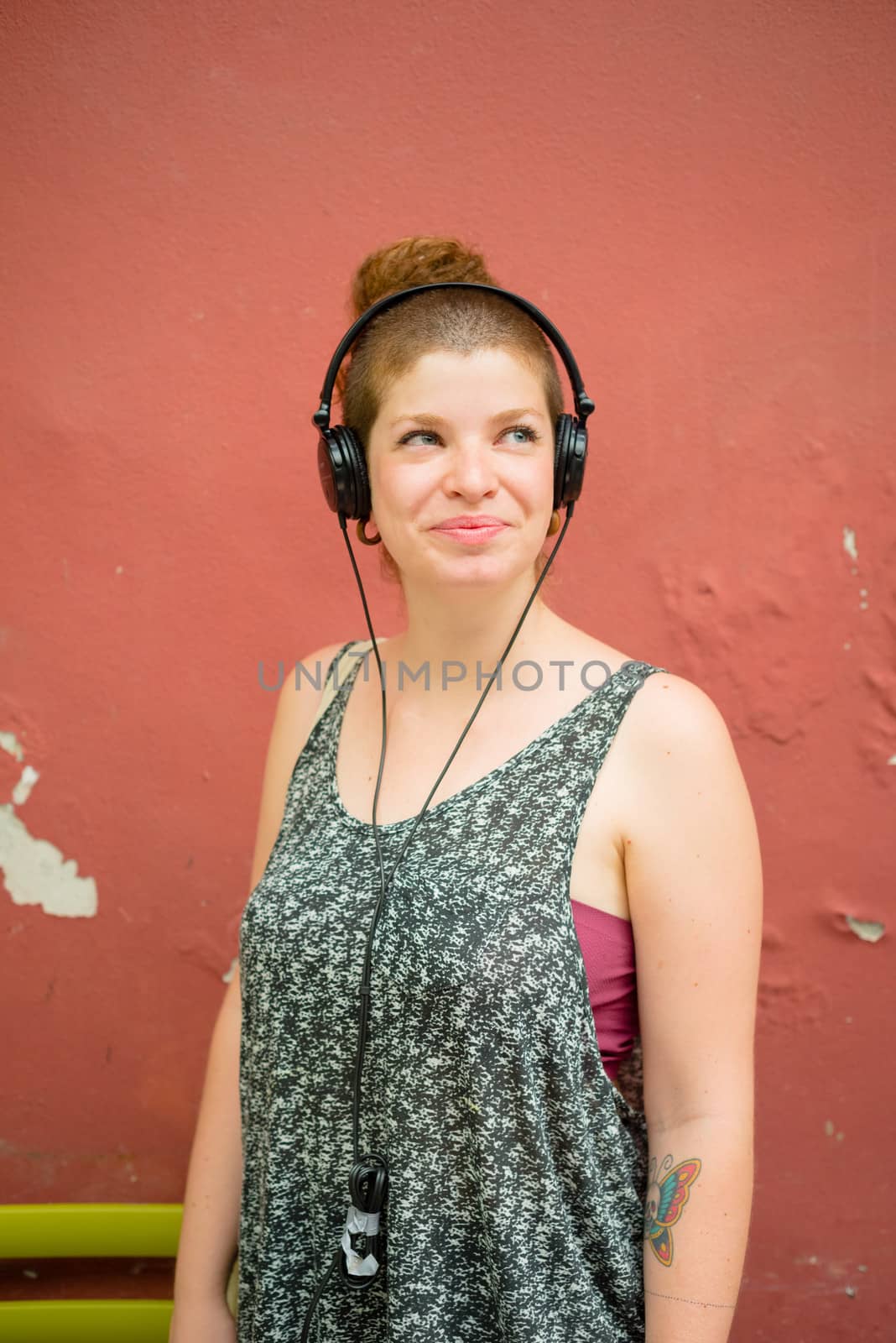 beautiful stylish modern young woman listening to music in the city