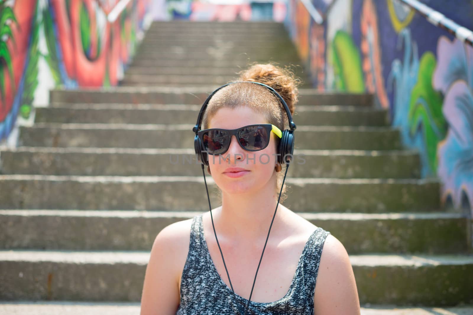 beautiful stylish modern young woman listening to music in the city