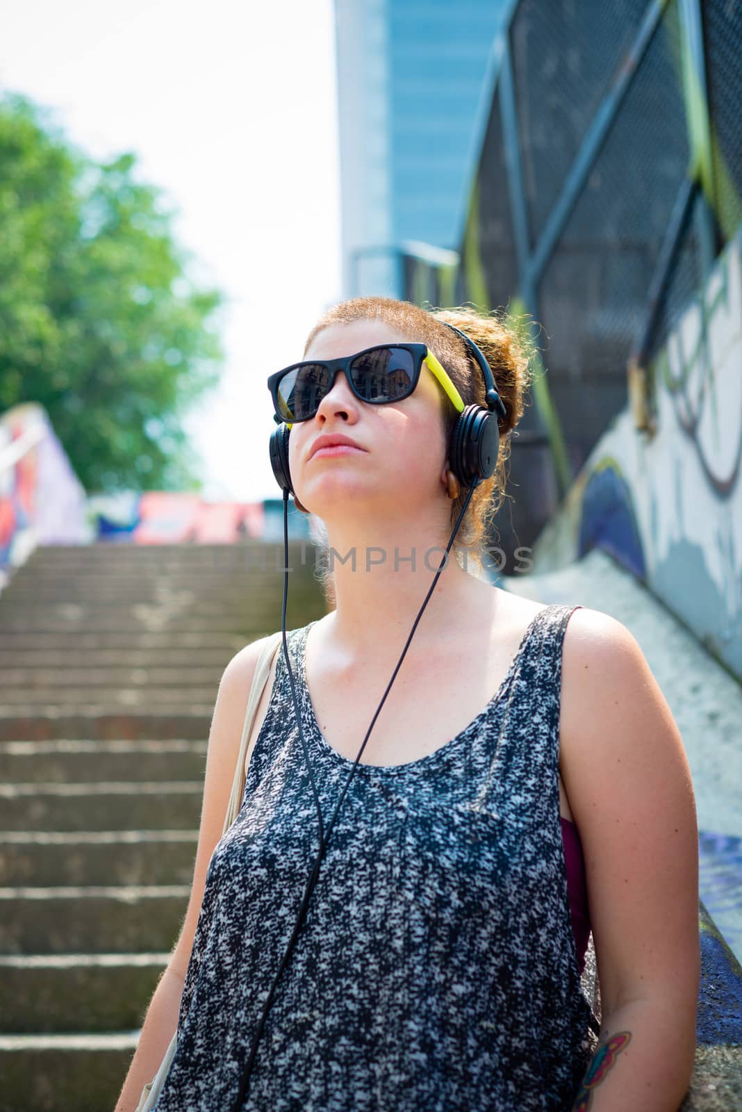 beautiful stylish modern young woman listening to music by peus