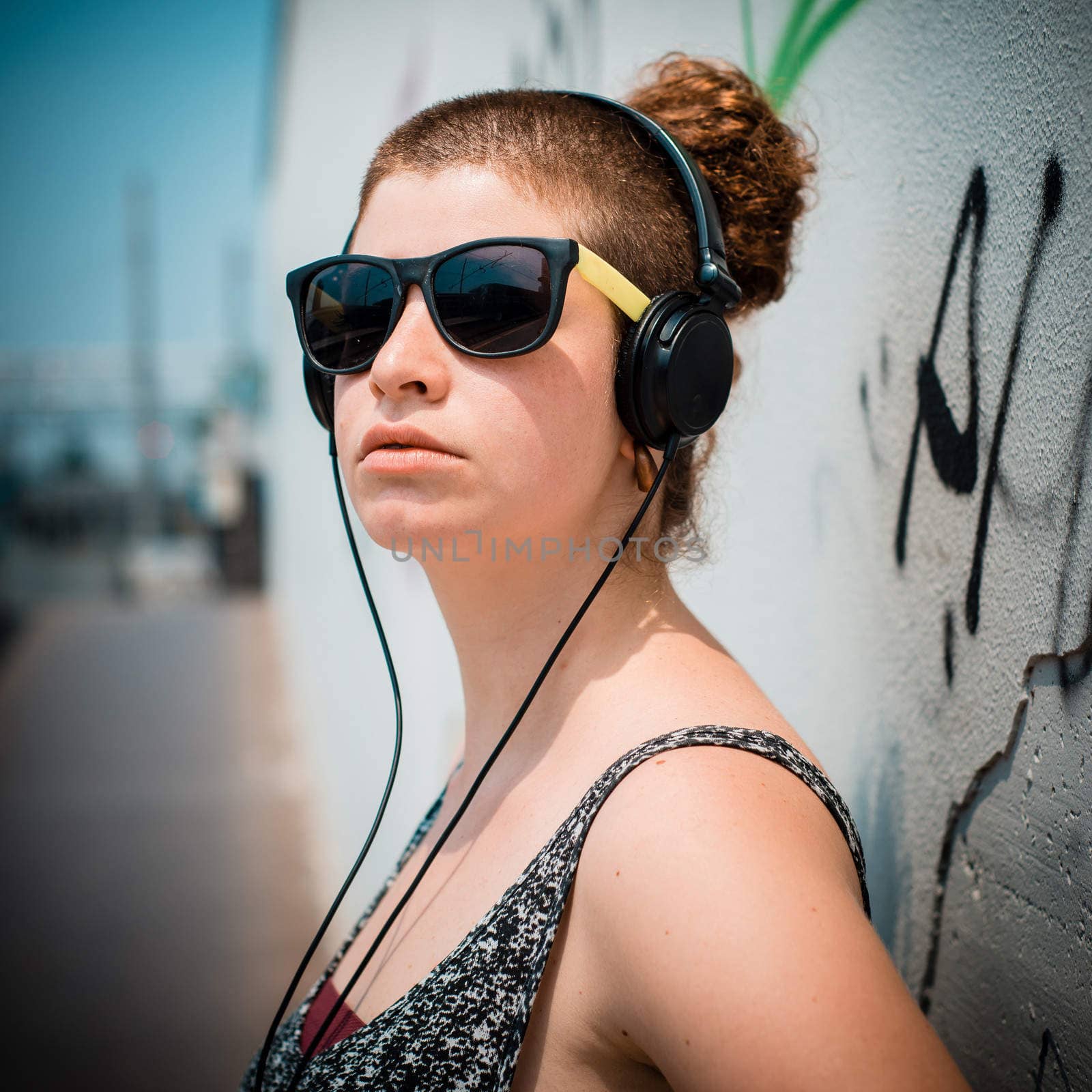 beautiful stylish modern young woman listening to music by peus