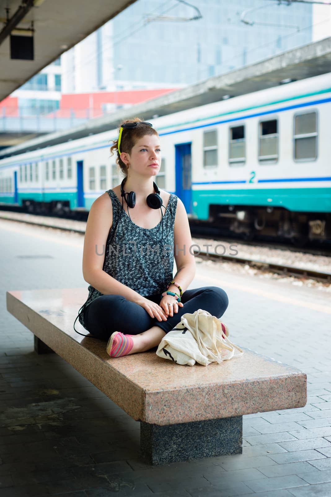 beautiful stylish modern young woman waiting train at the station