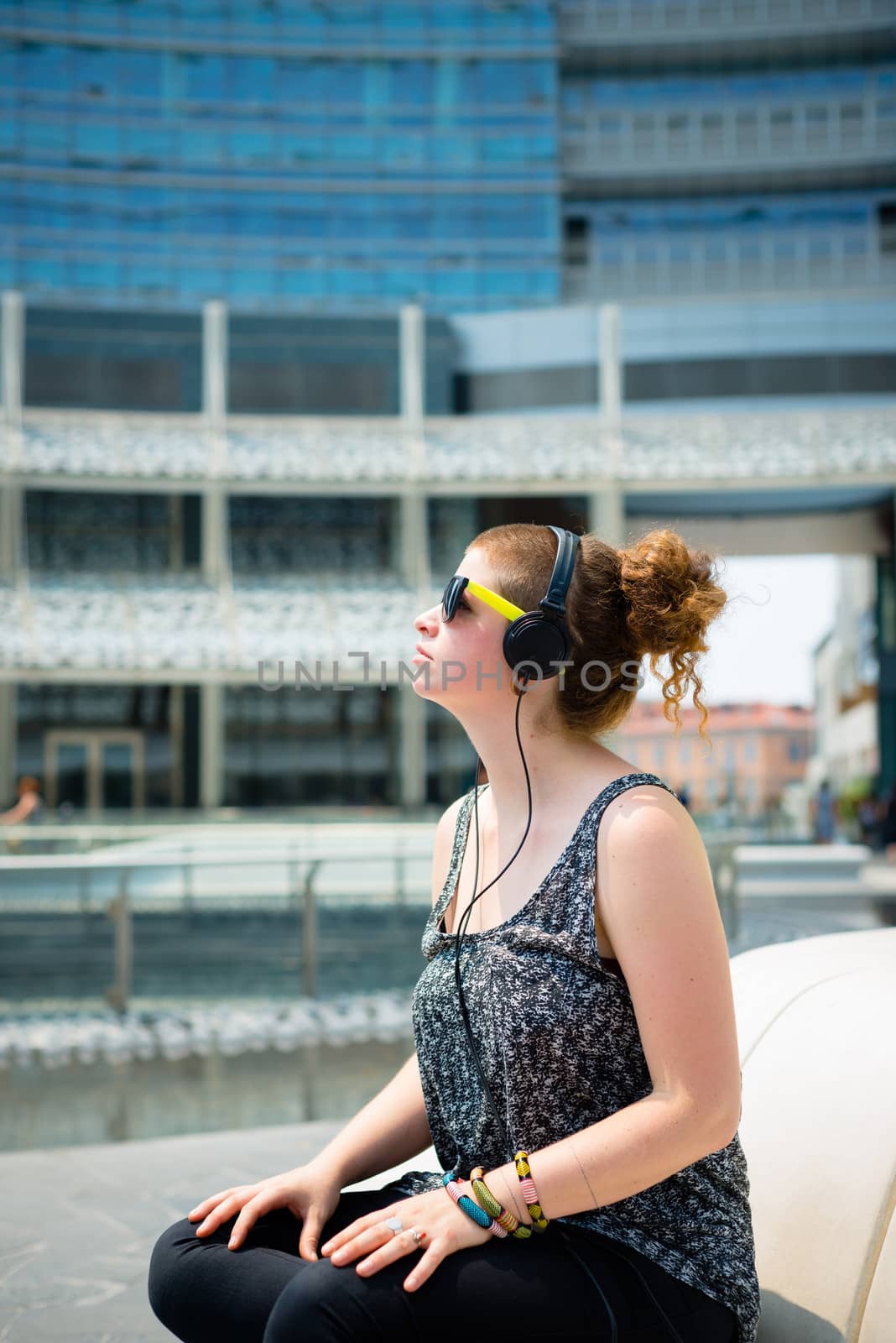 beautiful stylish modern young woman listening to music by peus