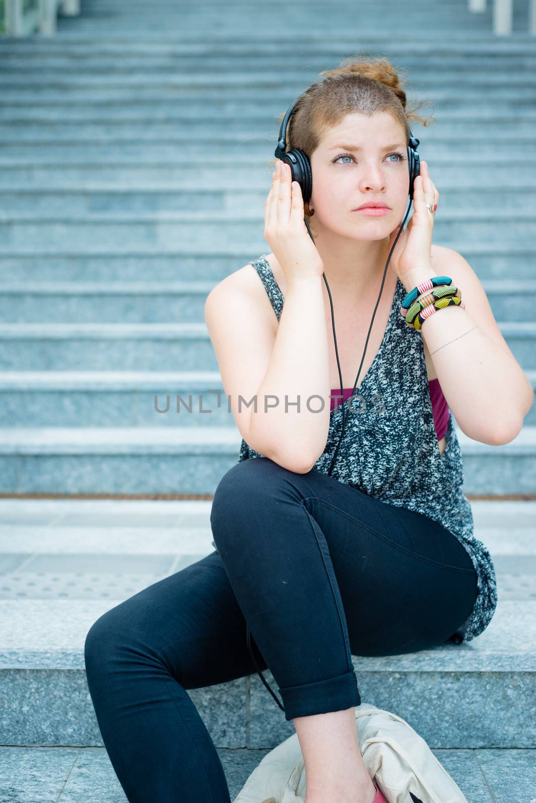 beautiful stylish modern young woman listening to music by peus