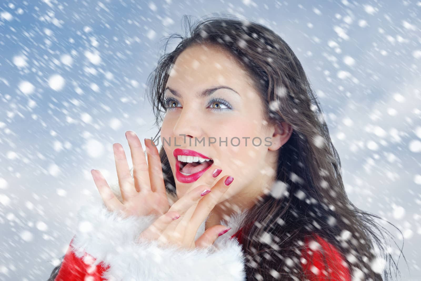 Happy smiling woman outdoors under the snow during Christmas