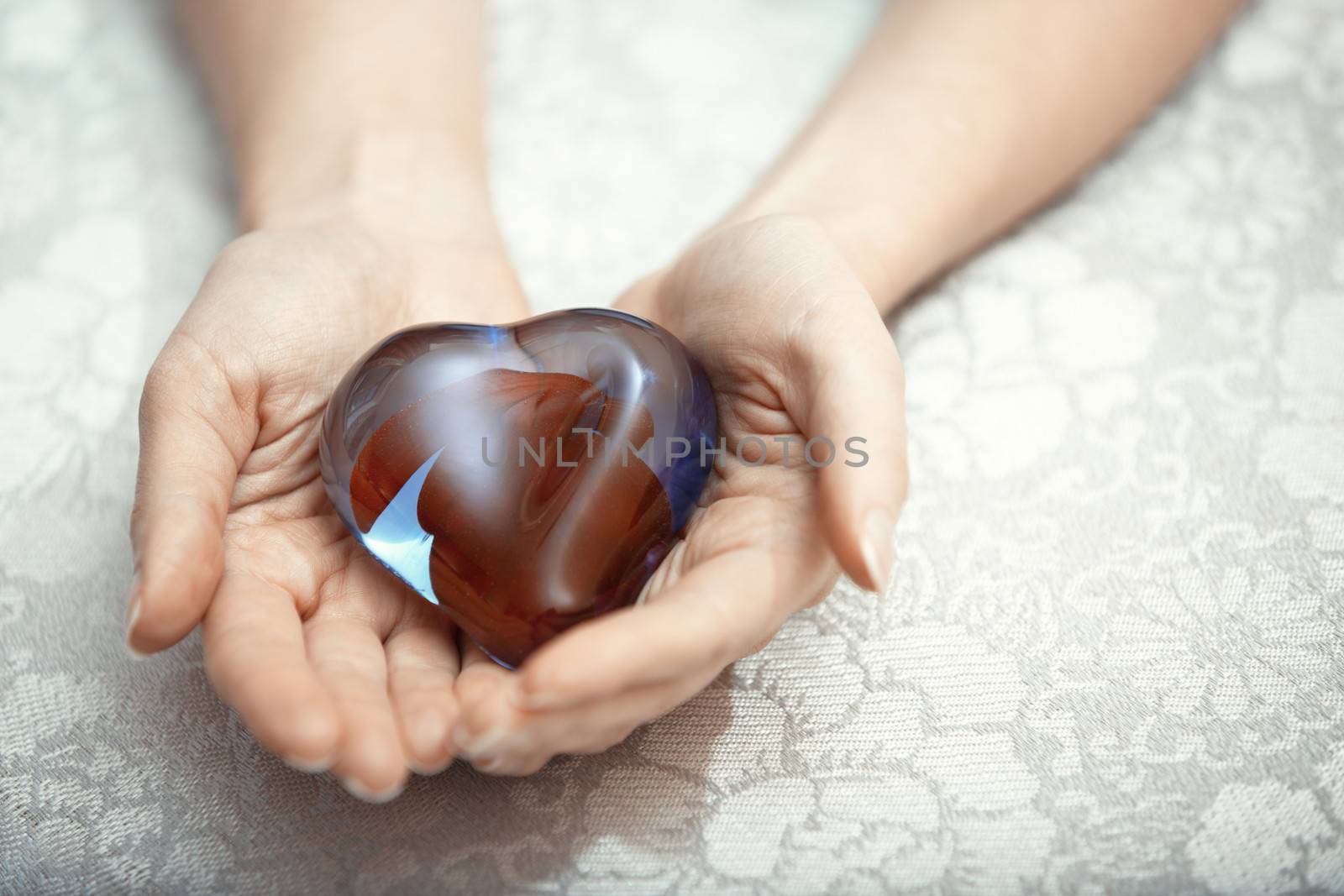 Woman hands holding heart shape object