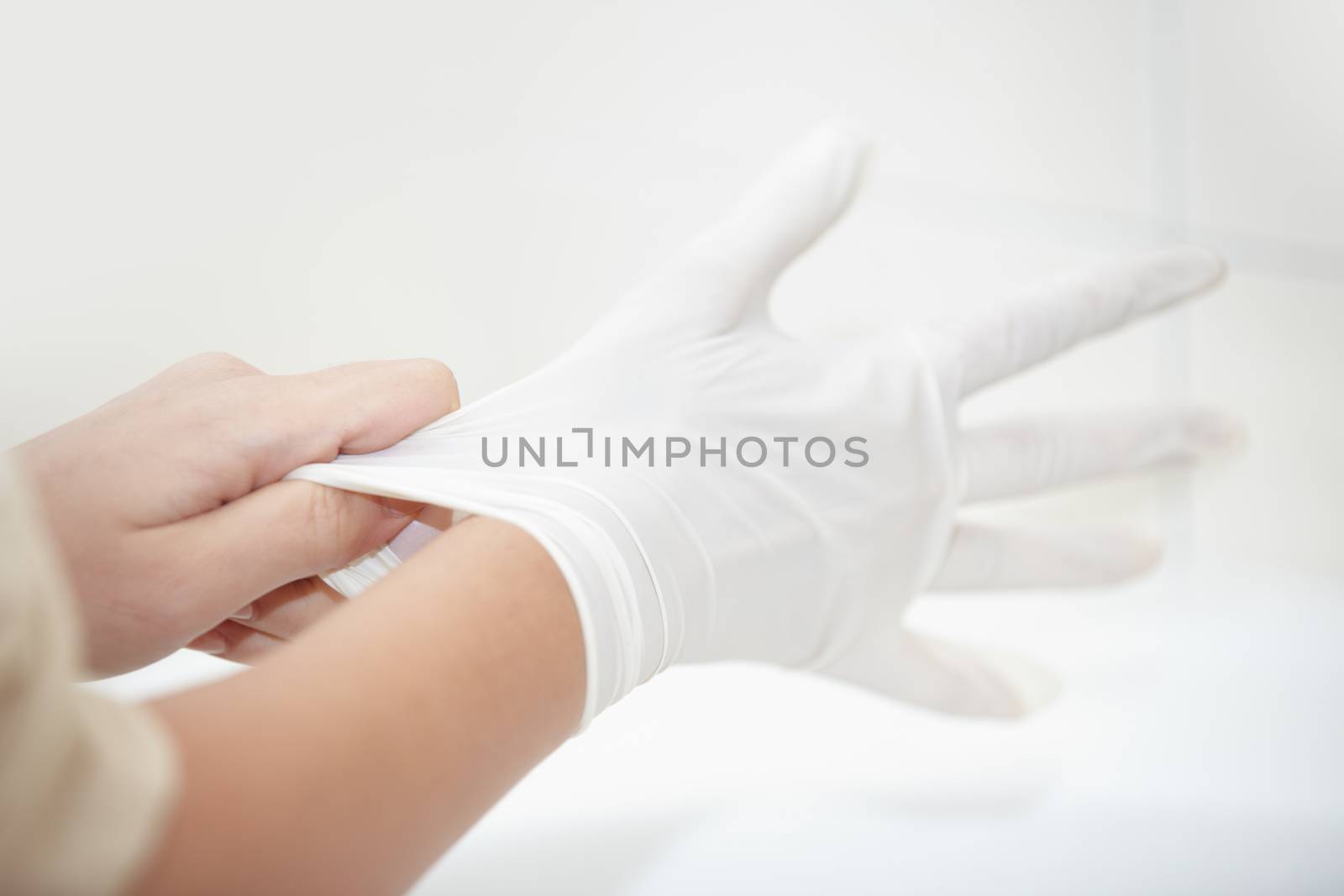 Hands of human taking on rubber gloves