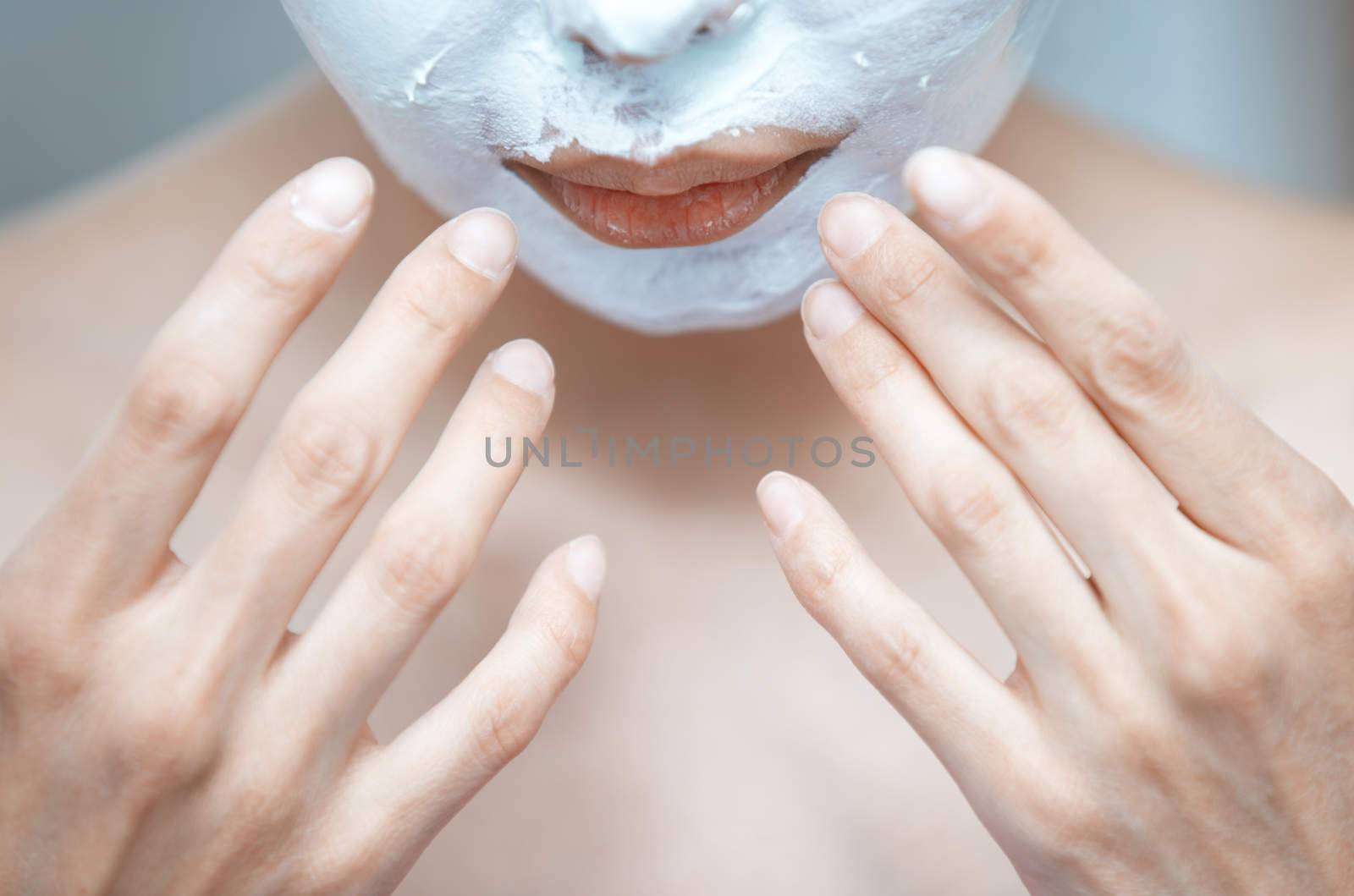 Woman applying moisturizing cream to the face