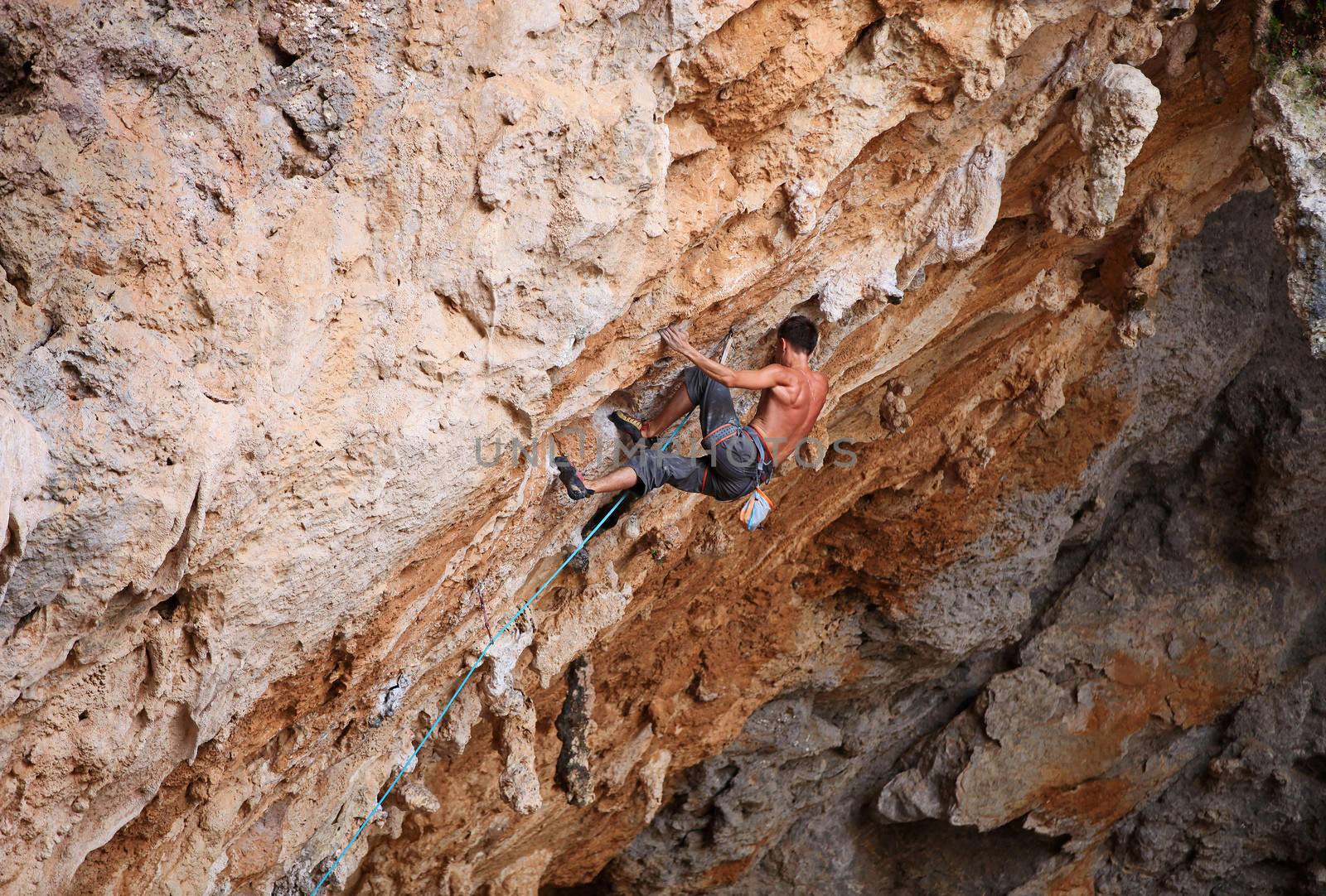 Male rock climber struggling his way up