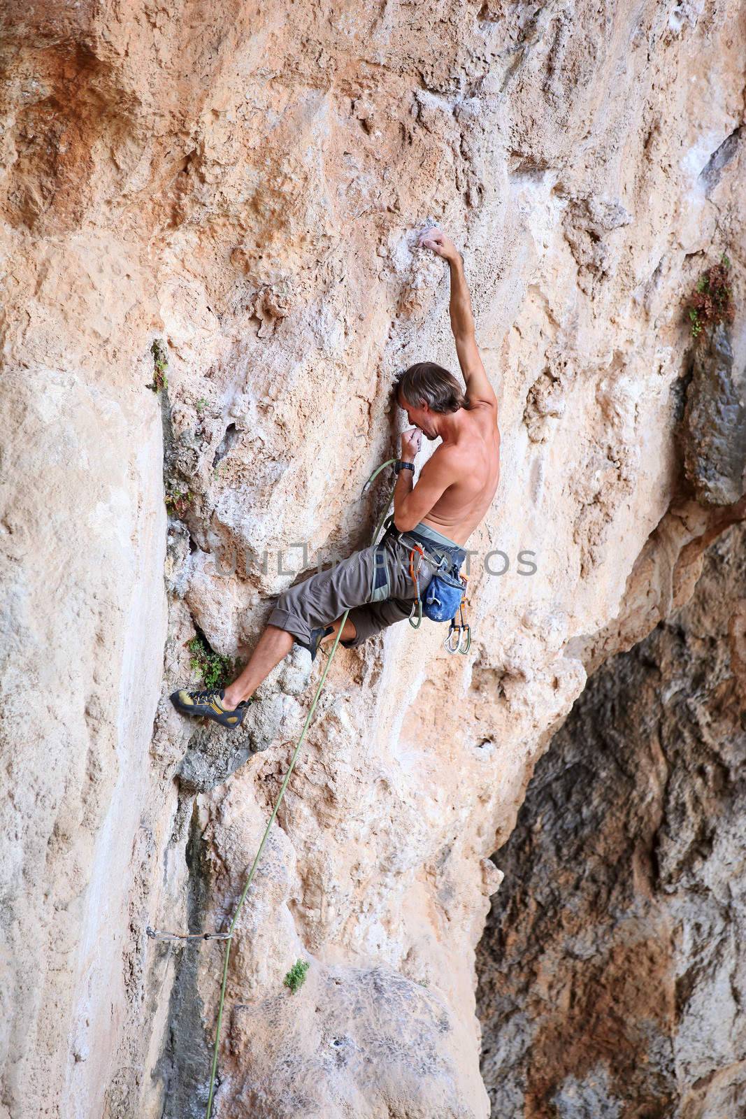 Rock climber on a cliff, vertical view