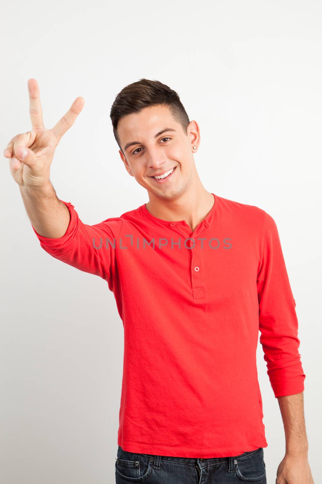 Young and handsome guy doing a peace sign by Izaphoto