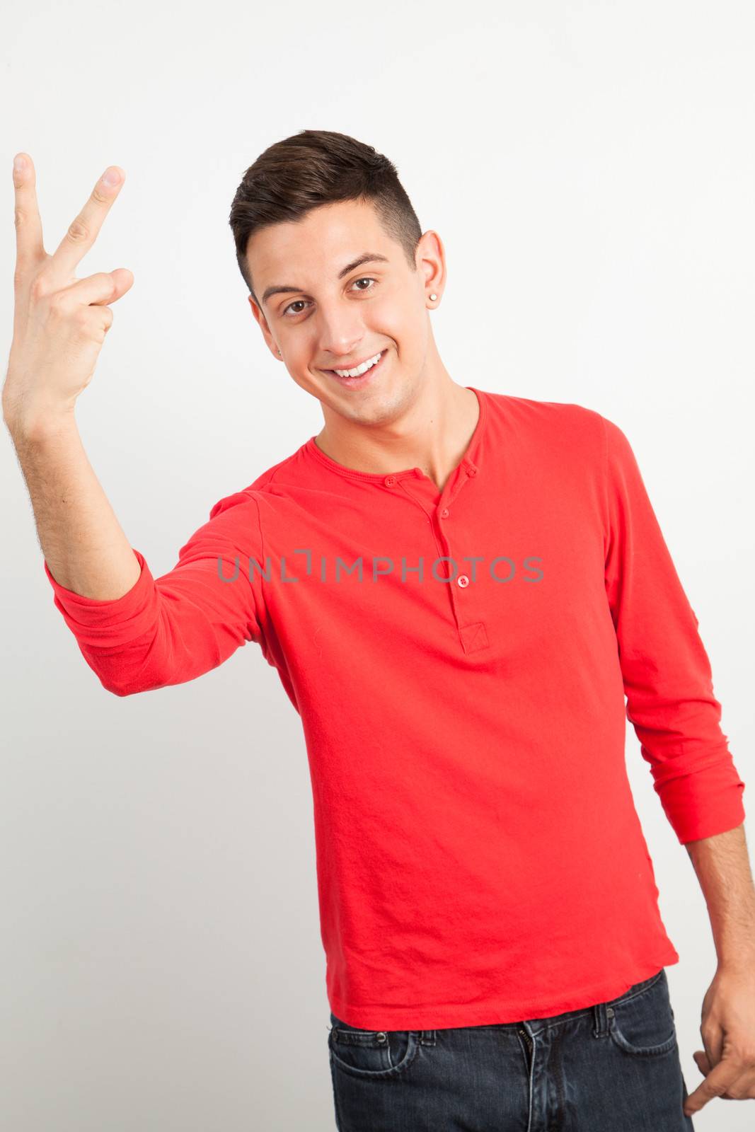 Young and handsome guy doing a peace sign by Izaphoto