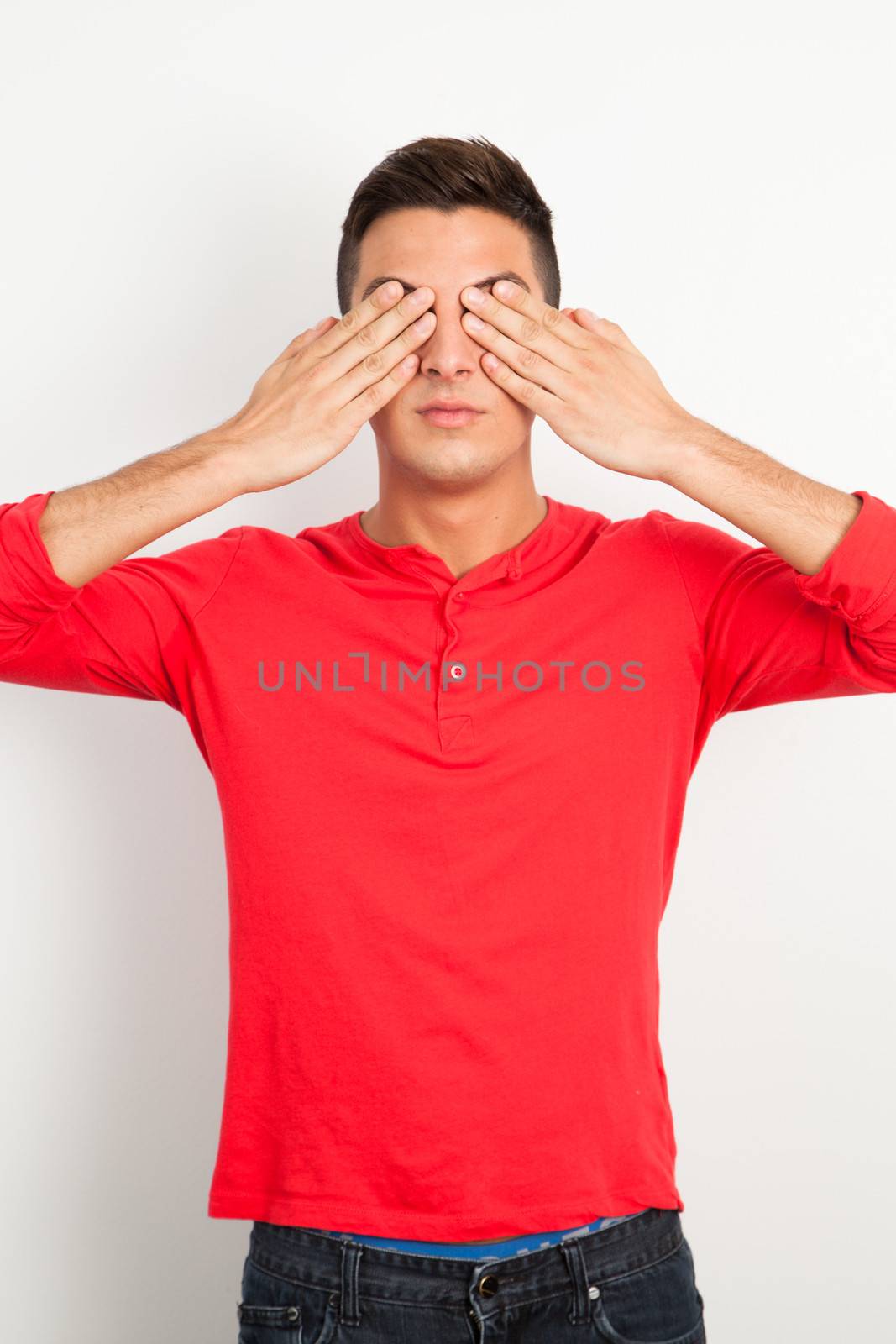 Young man covering his eyes by Izaphoto