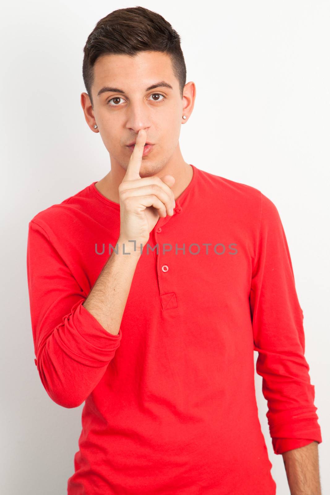 Young and handsome guy posing over white background