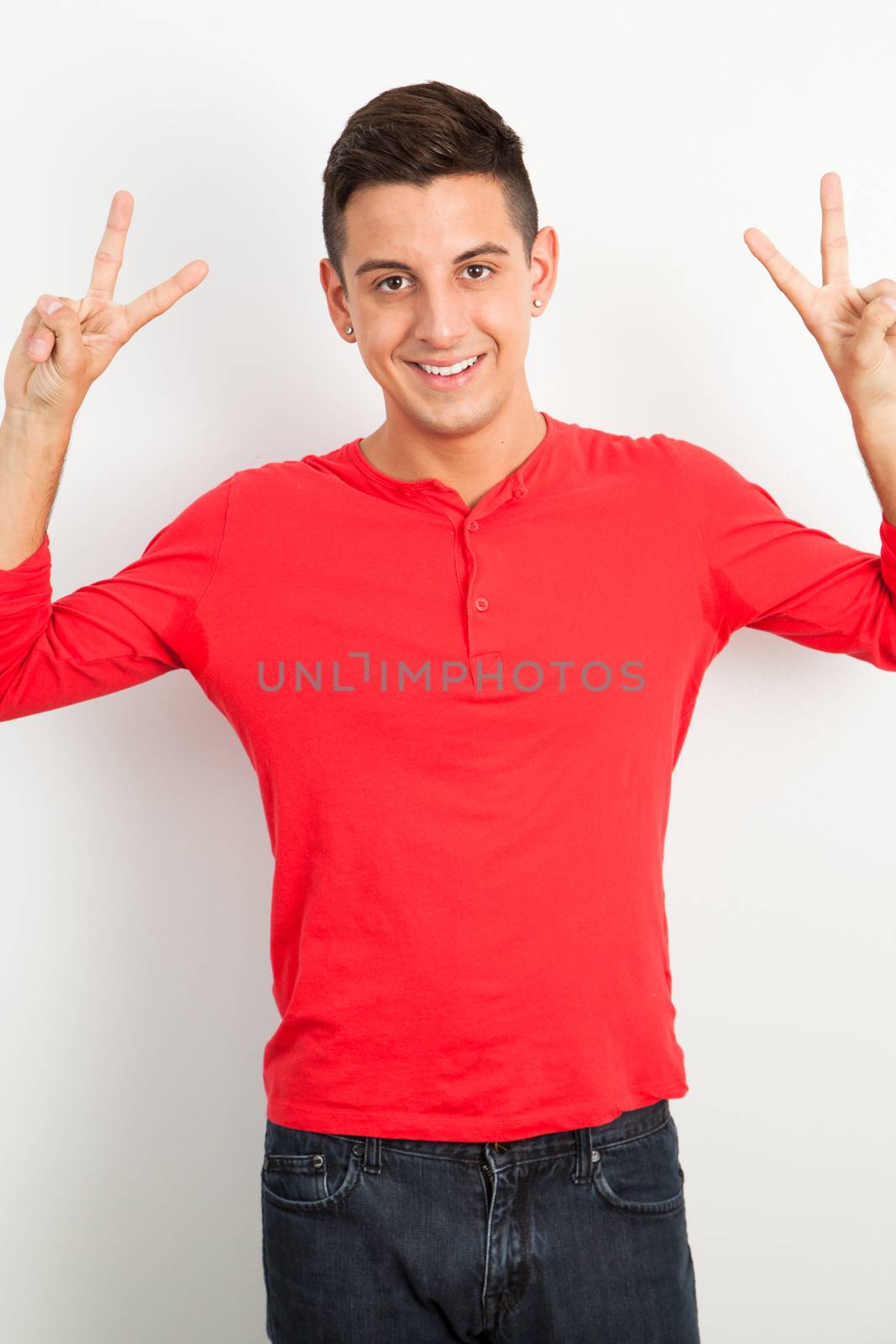 Young and handsome guy doing a peace sign by Izaphoto