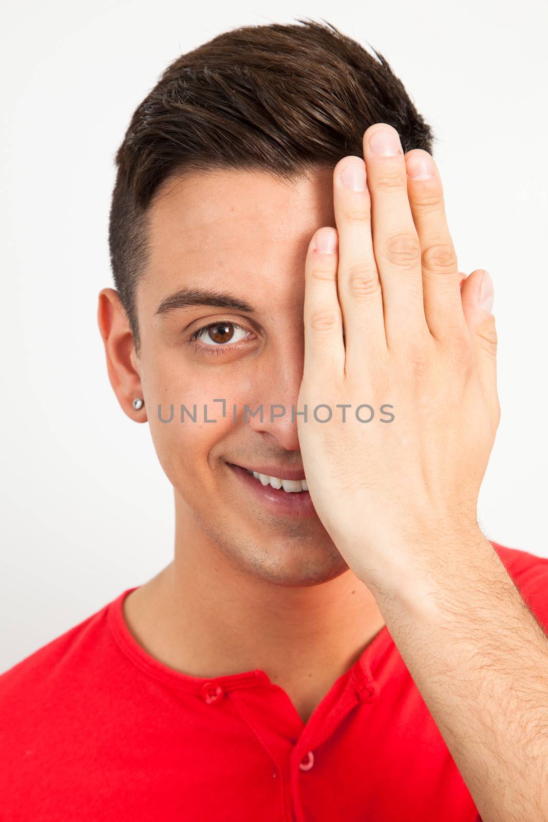 Young man covering one eye by Izaphoto