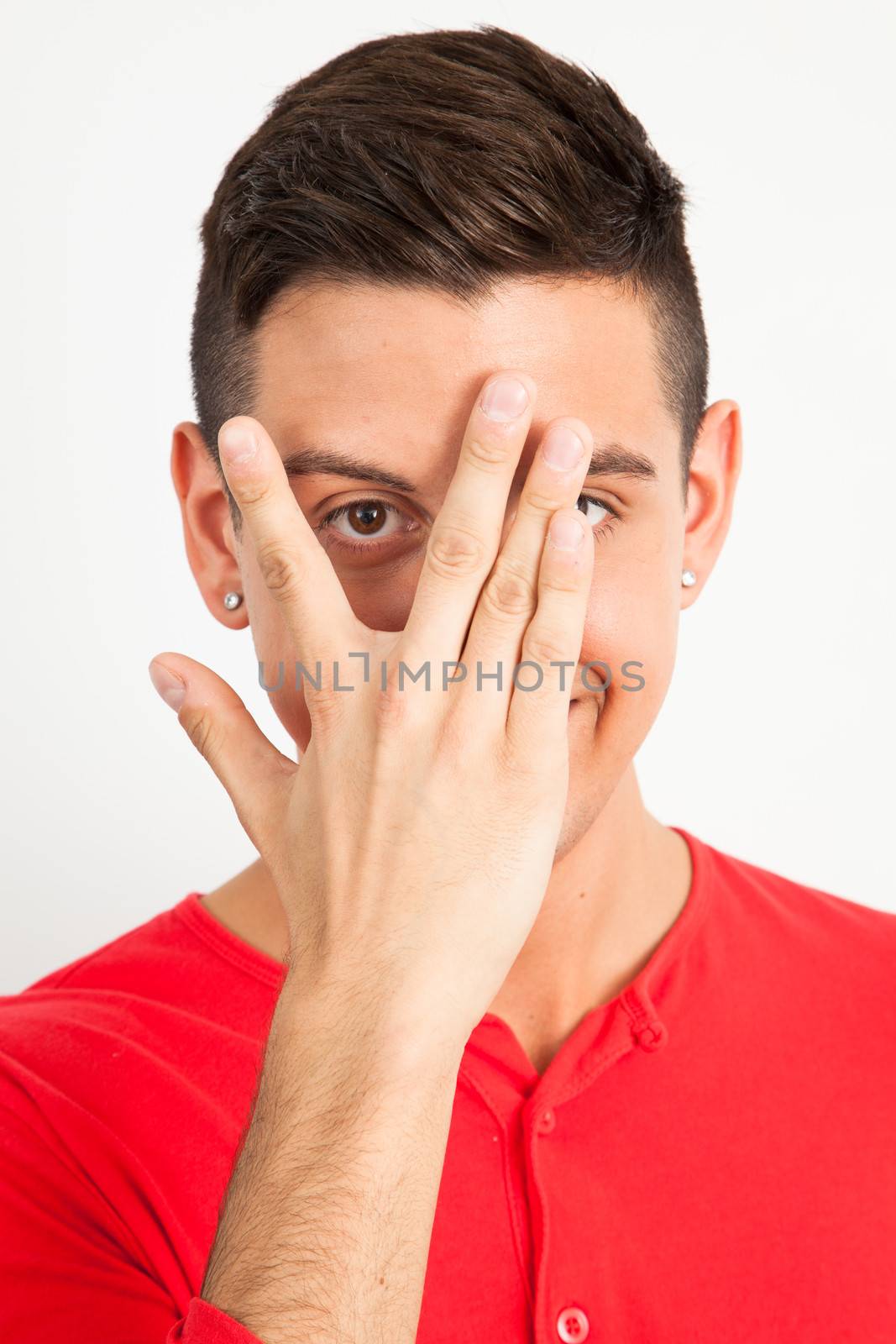 Young man covering one eye by Izaphoto