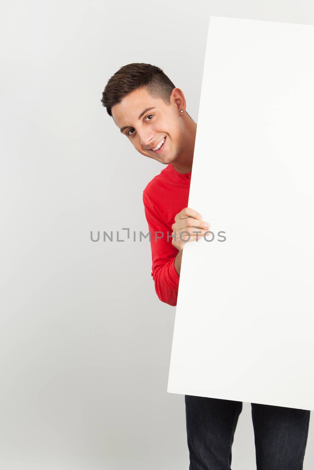 Young man holding a white board by Izaphoto