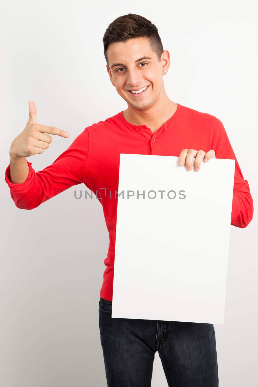 Young man holding a white board by Izaphoto