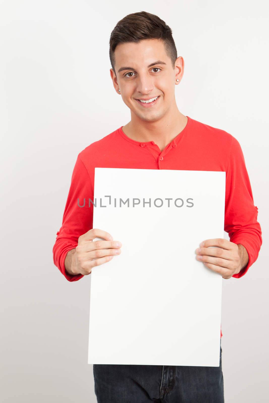 Young man holding a white board by Izaphoto