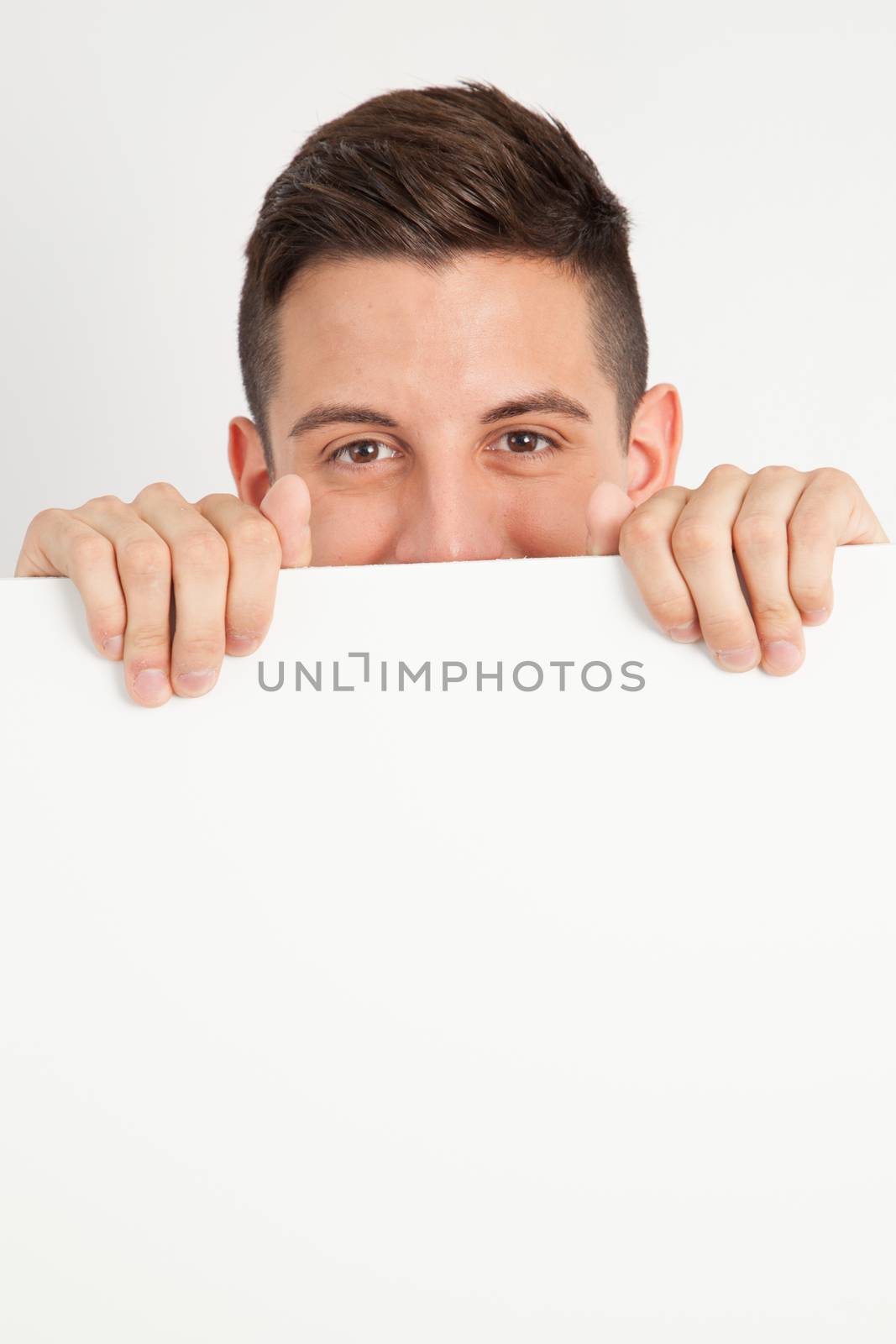 Young man holding a white board by Izaphoto