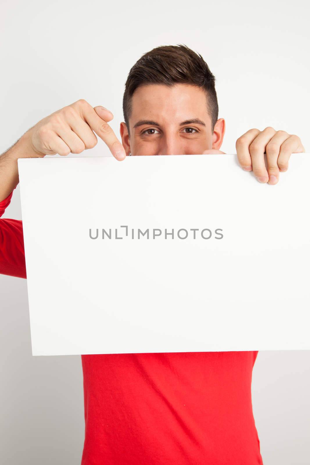 Young man holding a white board by Izaphoto