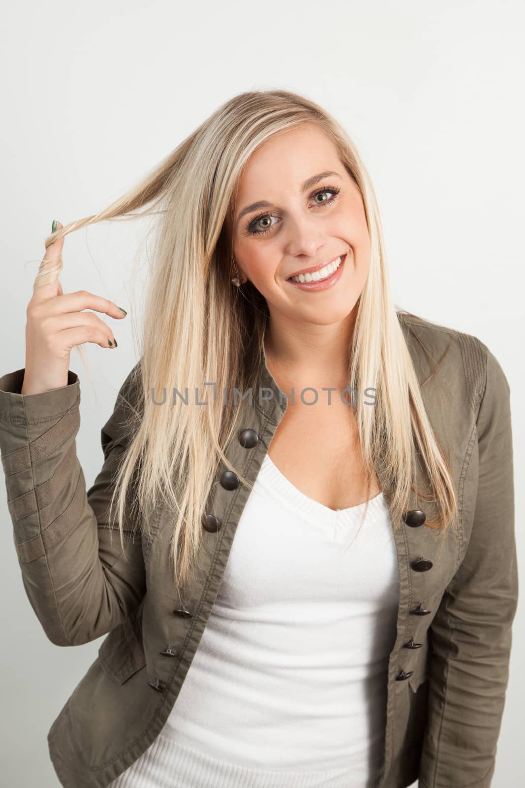 Young blond woman smiling against a white background