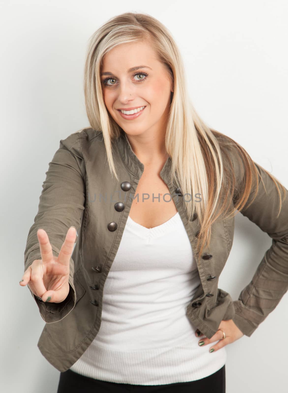 Young blond women smiling and doing a peace sign by Izaphoto