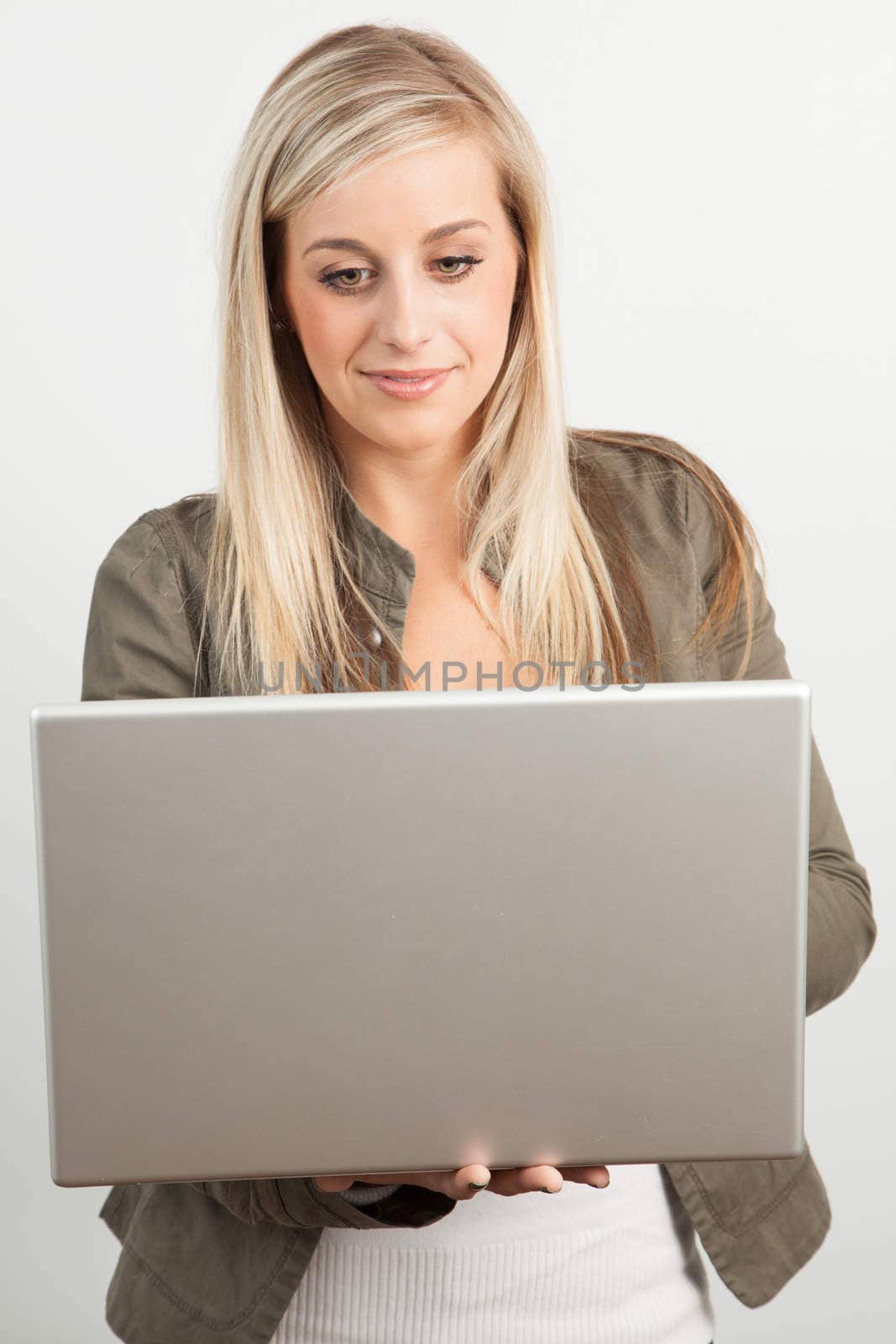Portrait of a young blond woman smiling with a laptop by Izaphoto