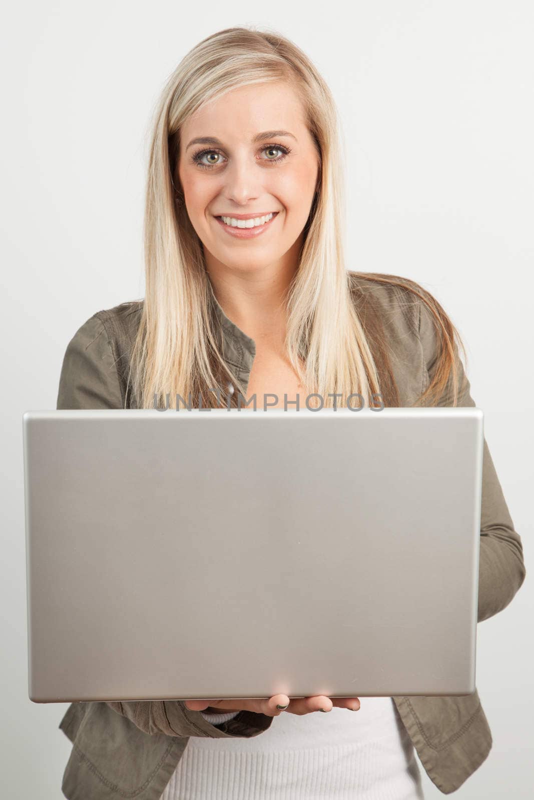 Young blond woman smiling against a white background