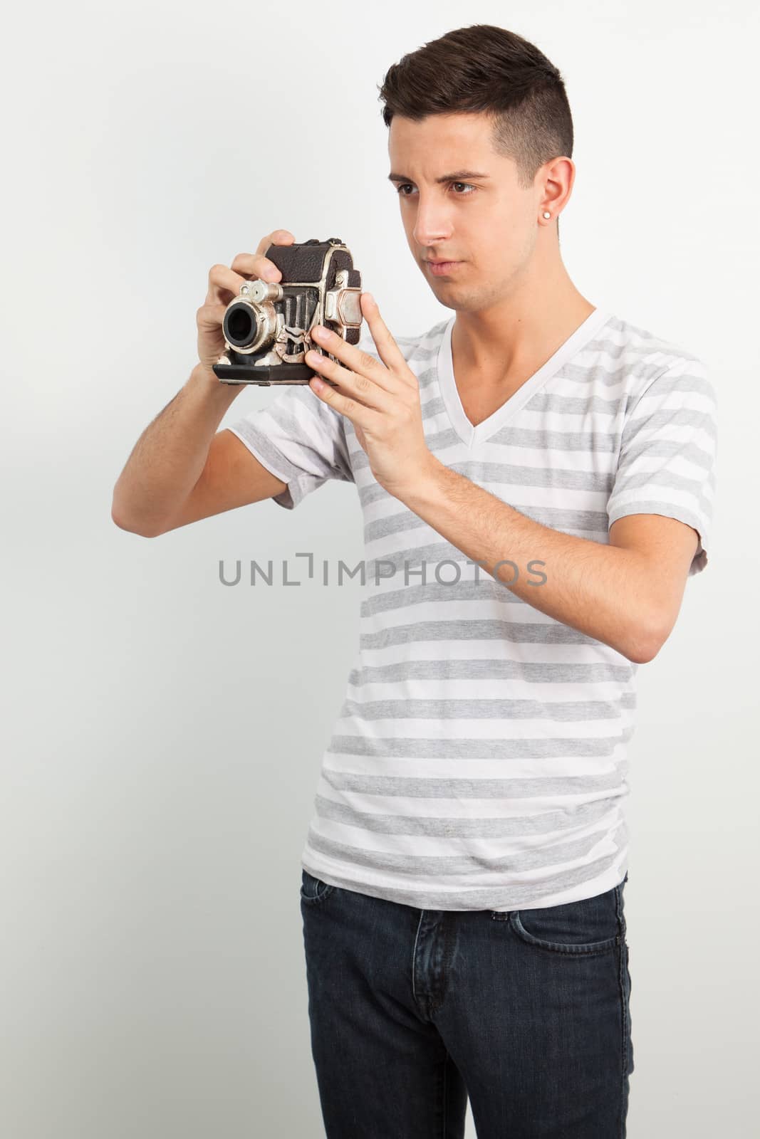 Young man using an old camera by Izaphoto