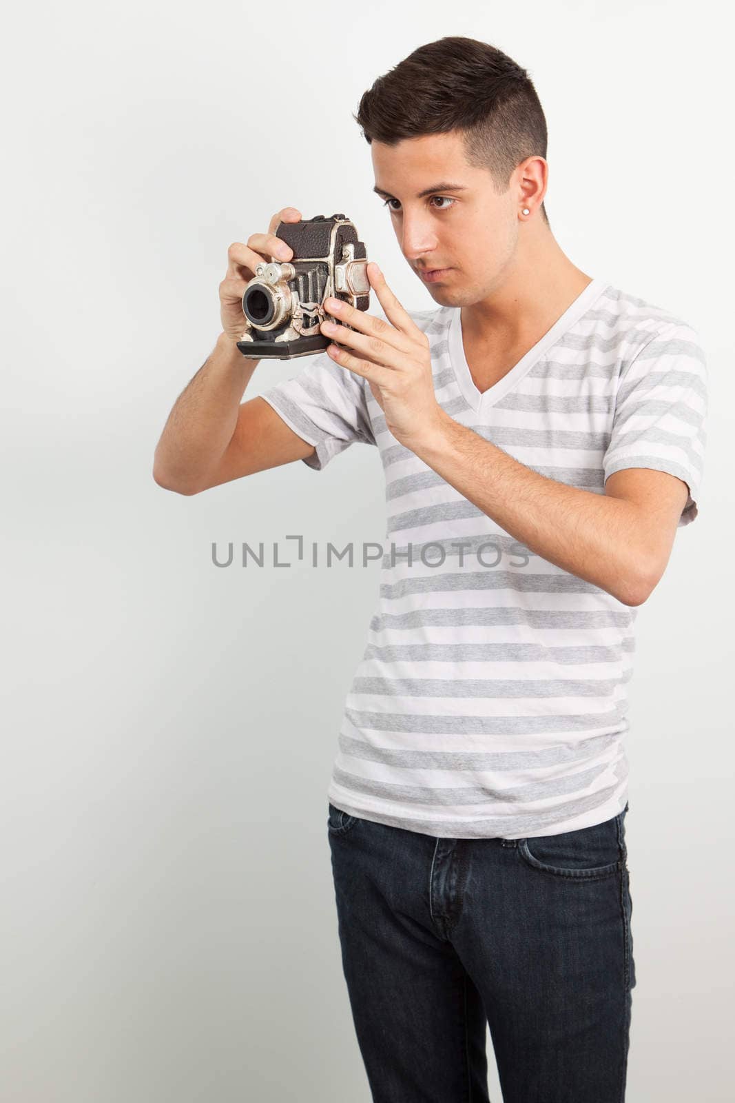 Young man using an old camera by Izaphoto