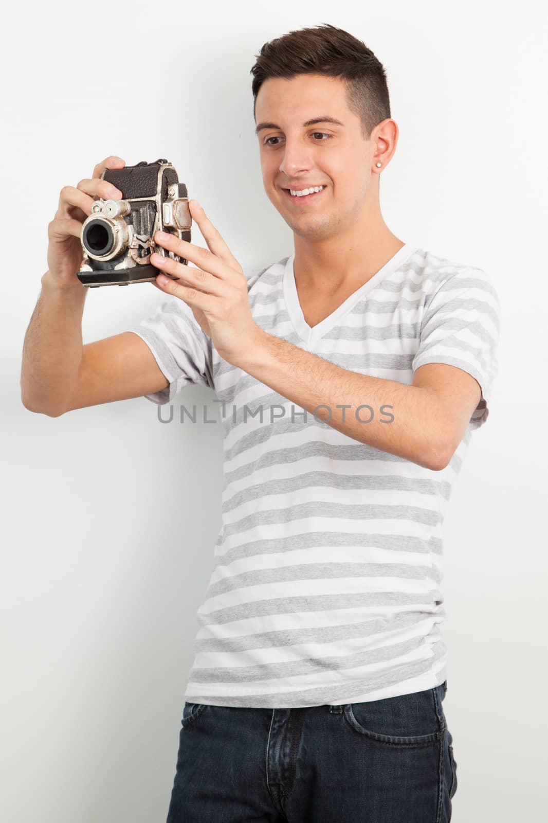 Young man using an old camera by Izaphoto