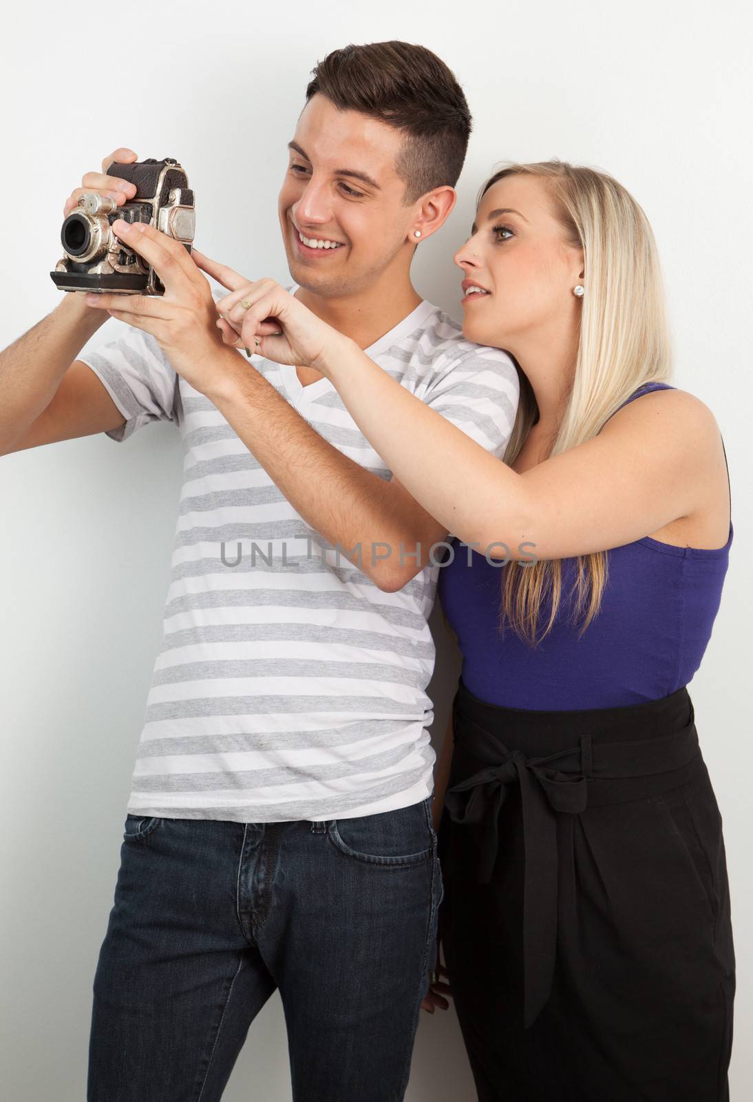 Young couple using an old camera by Izaphoto