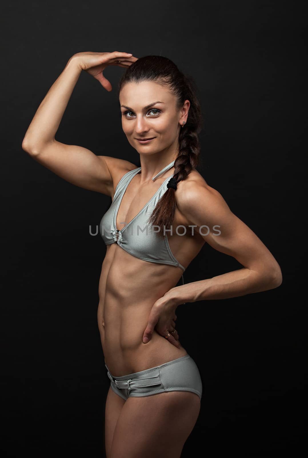 Fitness woman in bikini flexing bicep by photobac