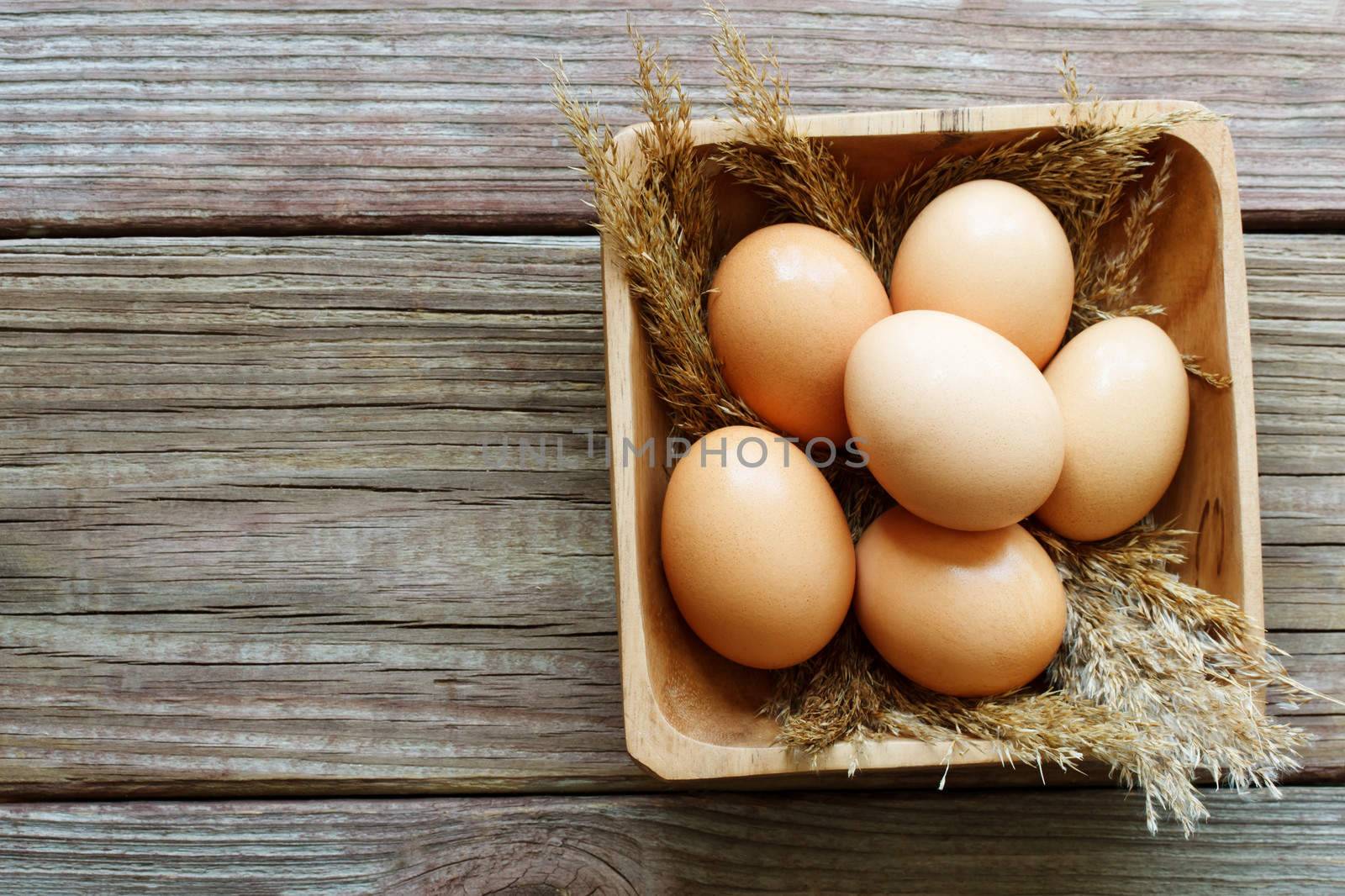 Fresh brown eggs on rustic wooden table