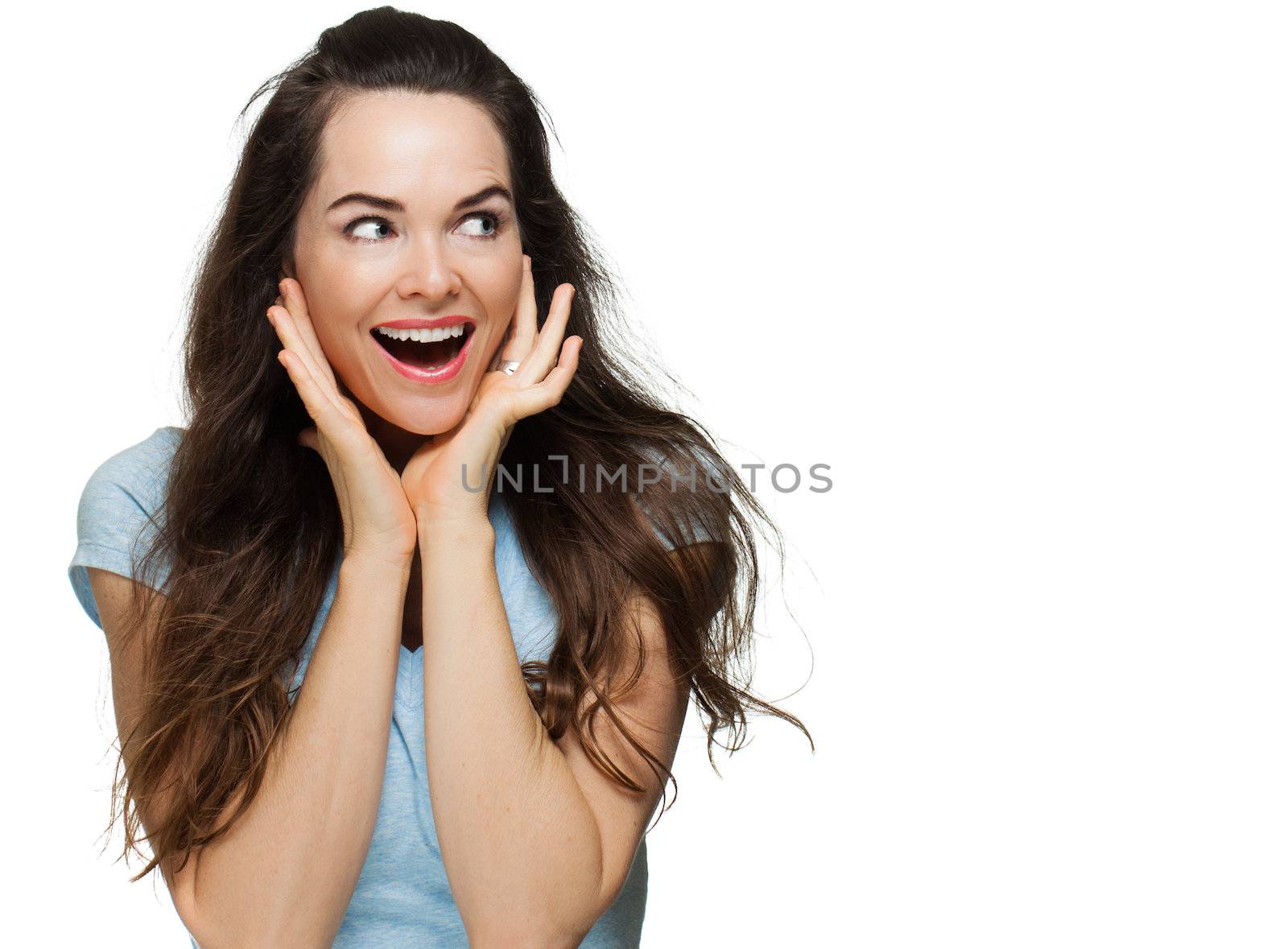 A beautiful surprised woman smiling and looking at copyspace. Isolated on white