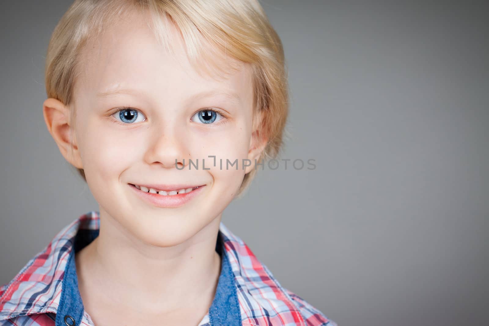 A close-up portrait of a cute happy young boy.