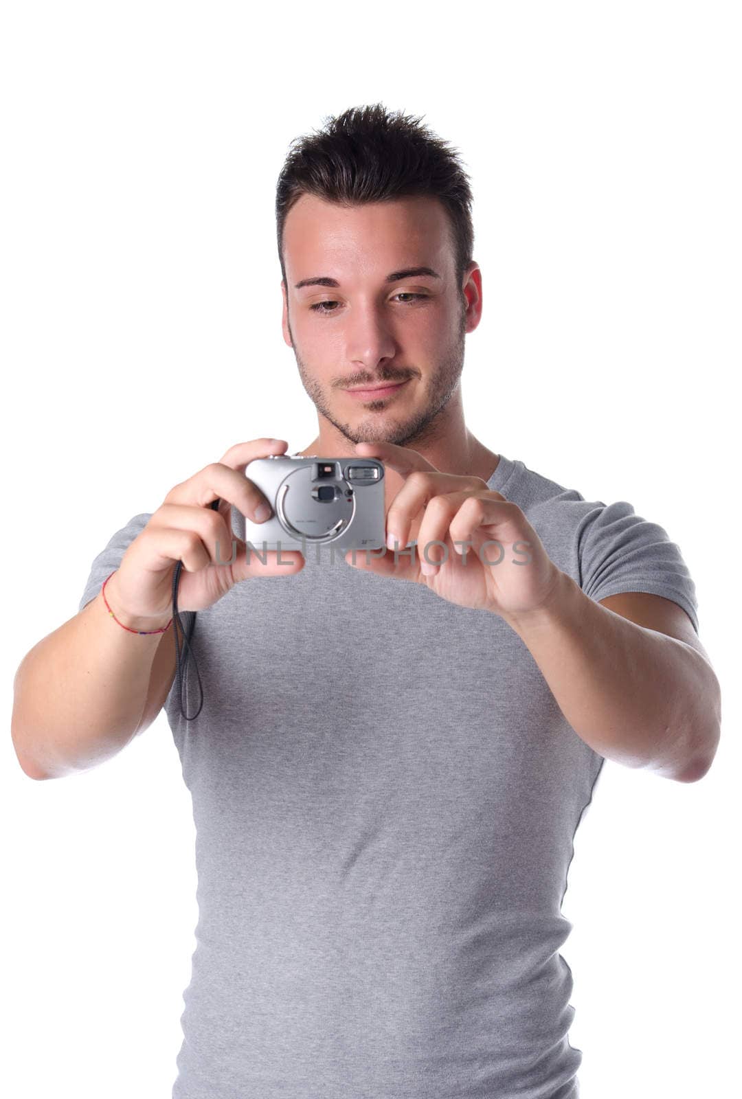 Attractive young man smiling and taking picture with compact photo camera