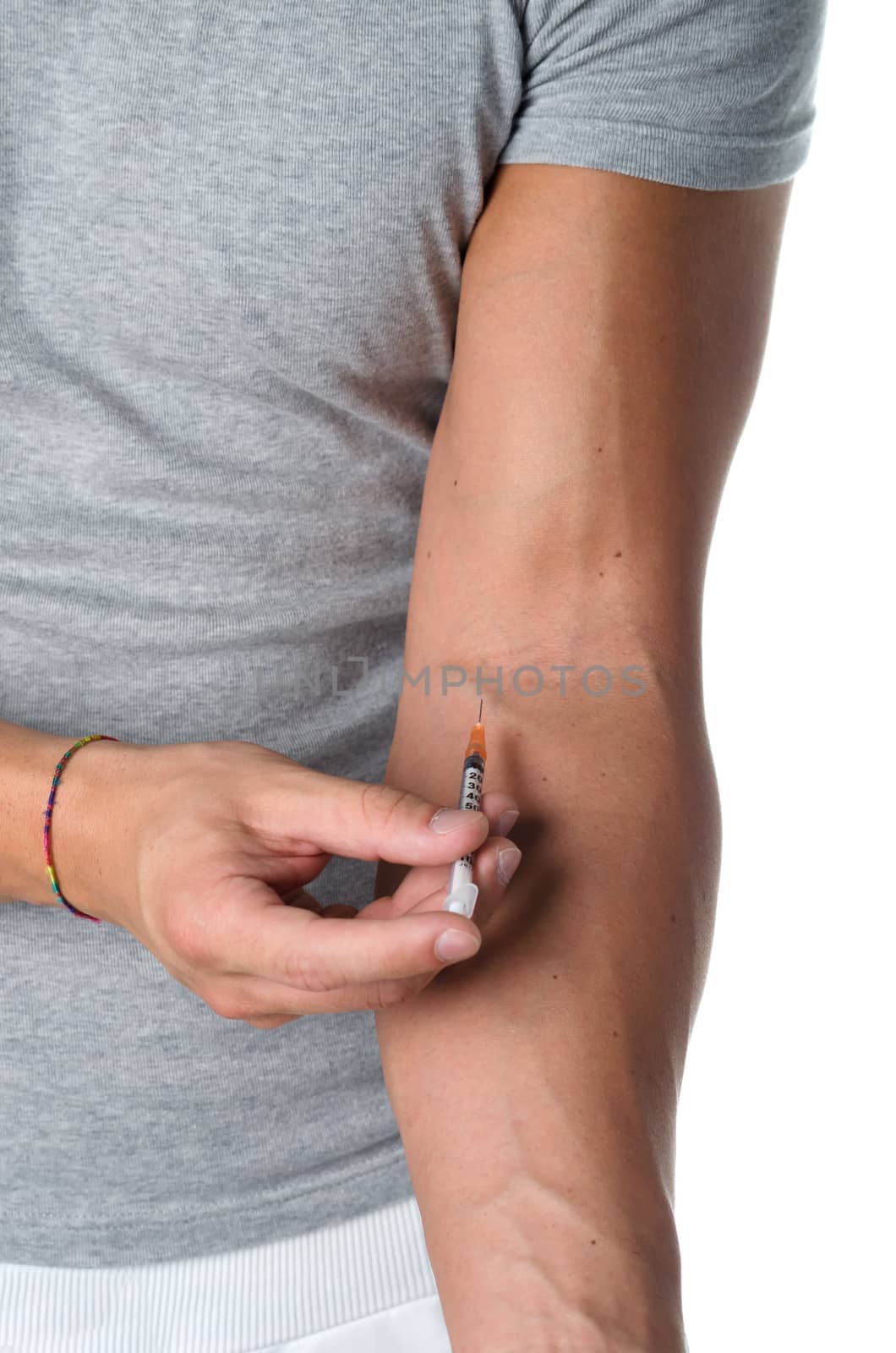 Closeup of young man injecting medicine in his arm by artofphoto