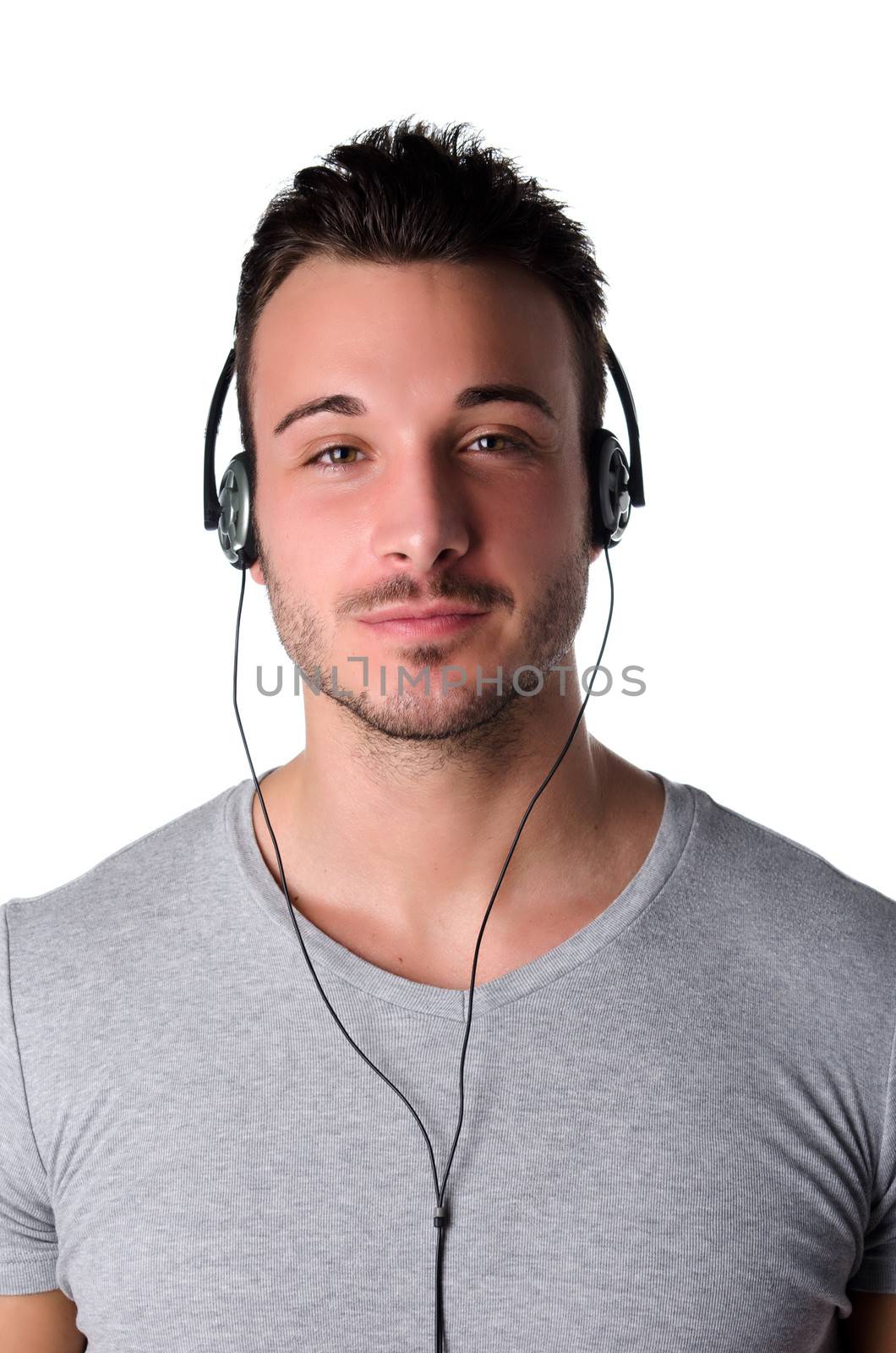 Handsome smiling young man with headphones listening to music, isolated on white