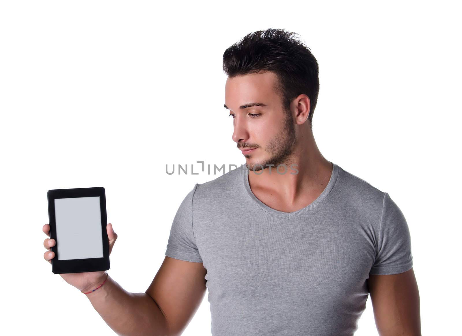 Handsome young man holding and looking at ebook reader, blank display, isolated on white